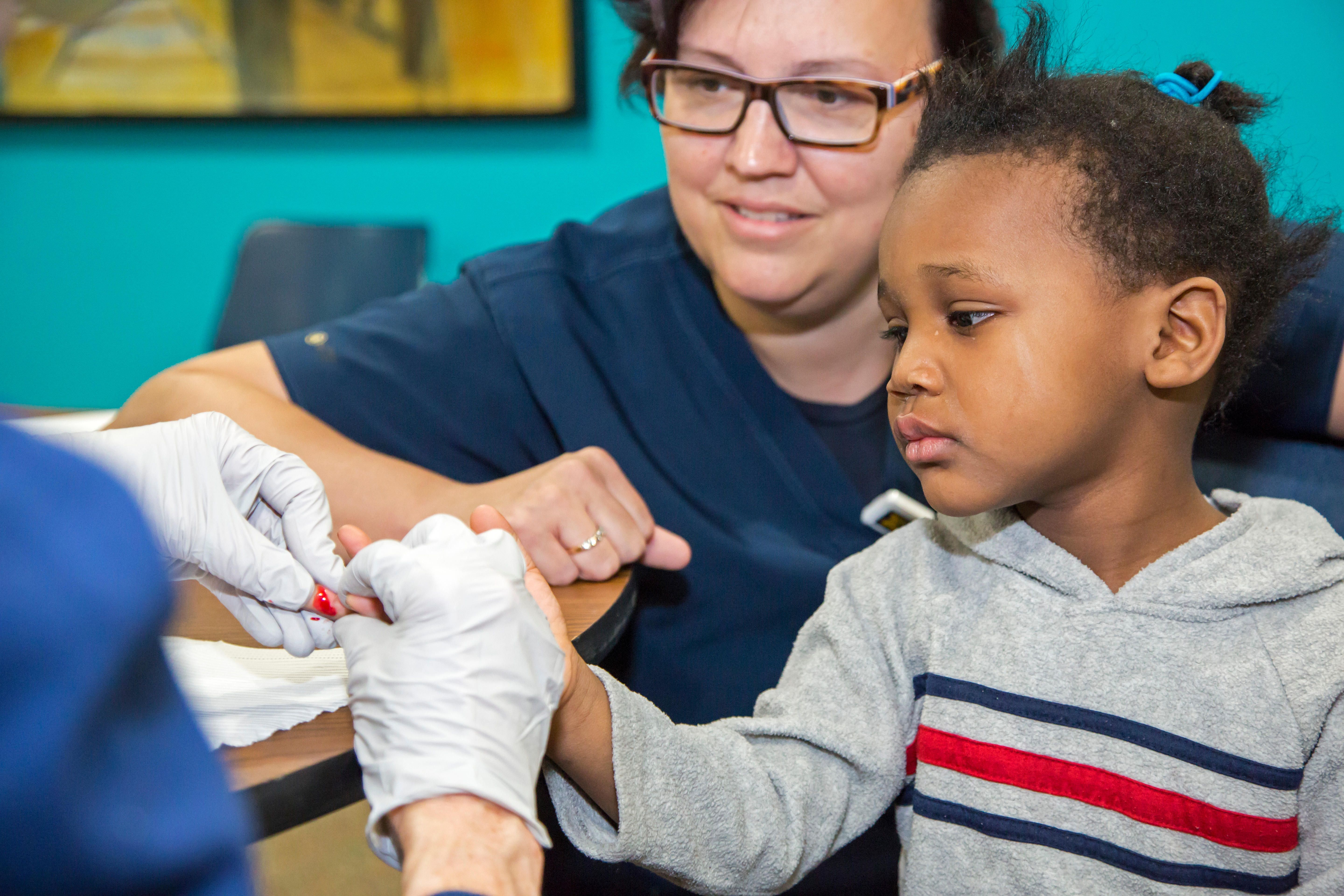 A volunteer nurse collects a blood sample from Maylaysia Valsin-Cooley, 3, to test for lead exposure in Flint, Michigan. Over 170 million U.S.-born people who were adults in 2015 were exposed to harmful levels of lead as children, a new study estimates.