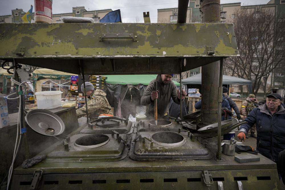 People cook outdoors for Ukrainian servicemen and civil defense members serving in Kyiv, Ukraine, Monday. The United Nations is unable to meet the needs of millions of civilians caught in conflict in Ukraine today and is urging safe passage for people to go "in the direction they choose" and for humanitarian supplies to get to areas of hostilities, according to the U.N. humanitarian chief.