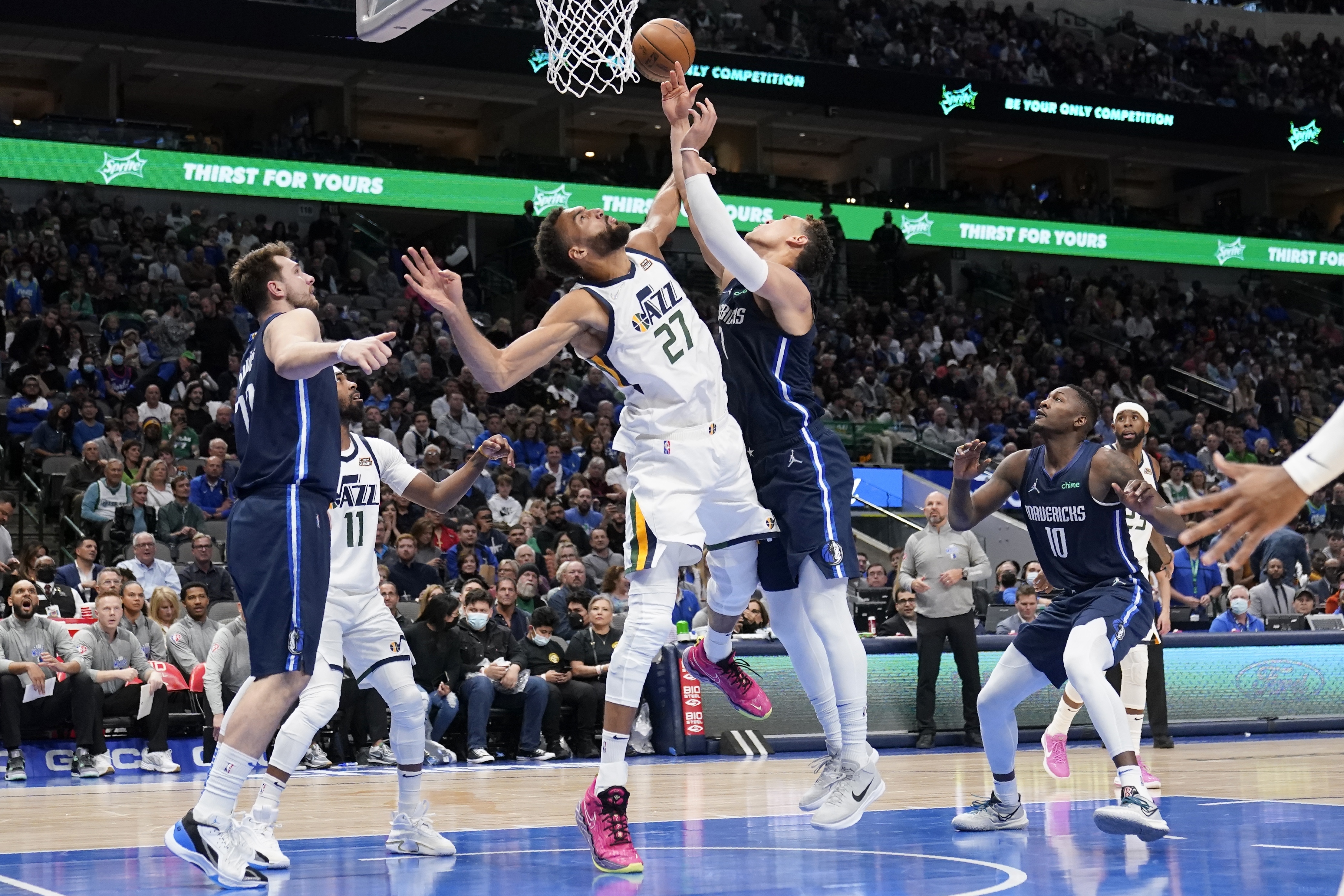 Utah Jazz center Rudy Gobert (27) blocks a shot-attempt by Dallas Mavericks center Dwight Powell, right, as Mavericks' Luka Doncic, left, looks on in the second half of an NBA basketball game in Dallas, Monday, March, 7, 2022. 