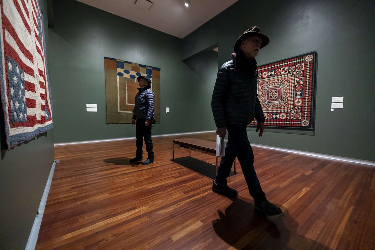 Suzanne and Hank Krause, of Colorado, look at the works in “Handstitched Worlds: The Cartography of Quilts” at the Utah Museum of Fine Arts at the University of Utah in Salt Lake City on Tuesday.