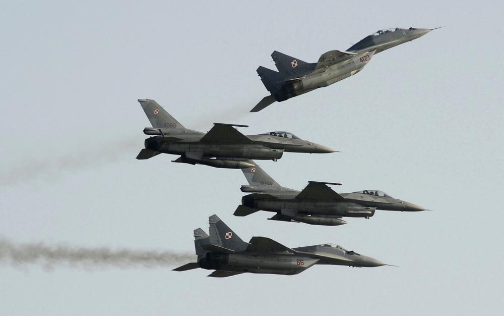 Two Polish Air Force Russian made Mig 29's fly above and below two Polish Air Force U.S. made F-16's fighter jets during the Air Show in Radom, Poland, on Aug. 27, 2011. In a private video call with American lawmakers over the weekend, Ukrainian President Volodymyr Zelenskyy made a “desperate” plea to the United States to help Kyiv get more warplanes to fight Russia's invasion and retain control of its airspace. 
