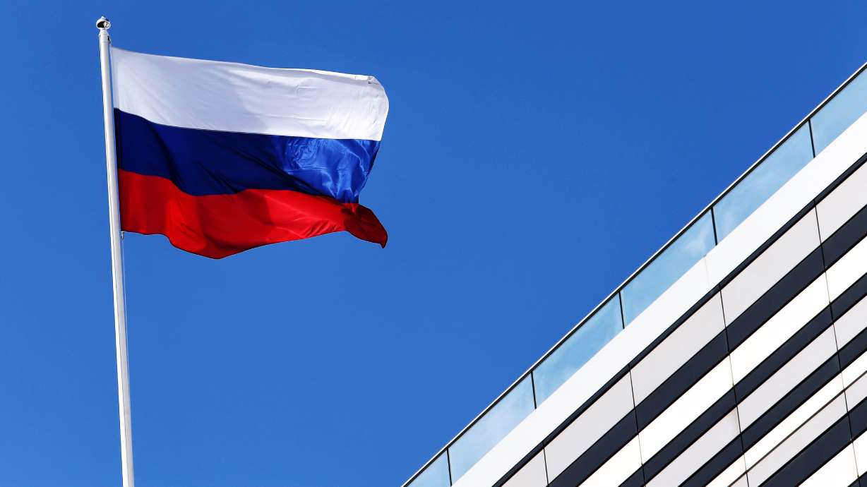 The Russian flag flies at the Russian Grand Prix, Sept. 27, 2018, in Sochi, Russia. A dual Russian-American citizen has been charged with acting as a spy in the U.S., according to court filings.