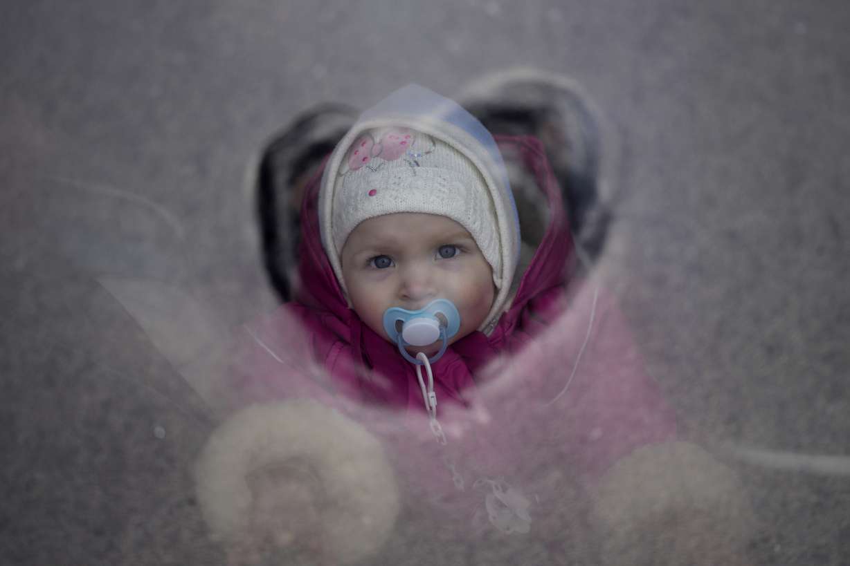 A child who fled the war from neighboring Ukraine looks through a bus window in Przemysl, Poland, Wednesday.