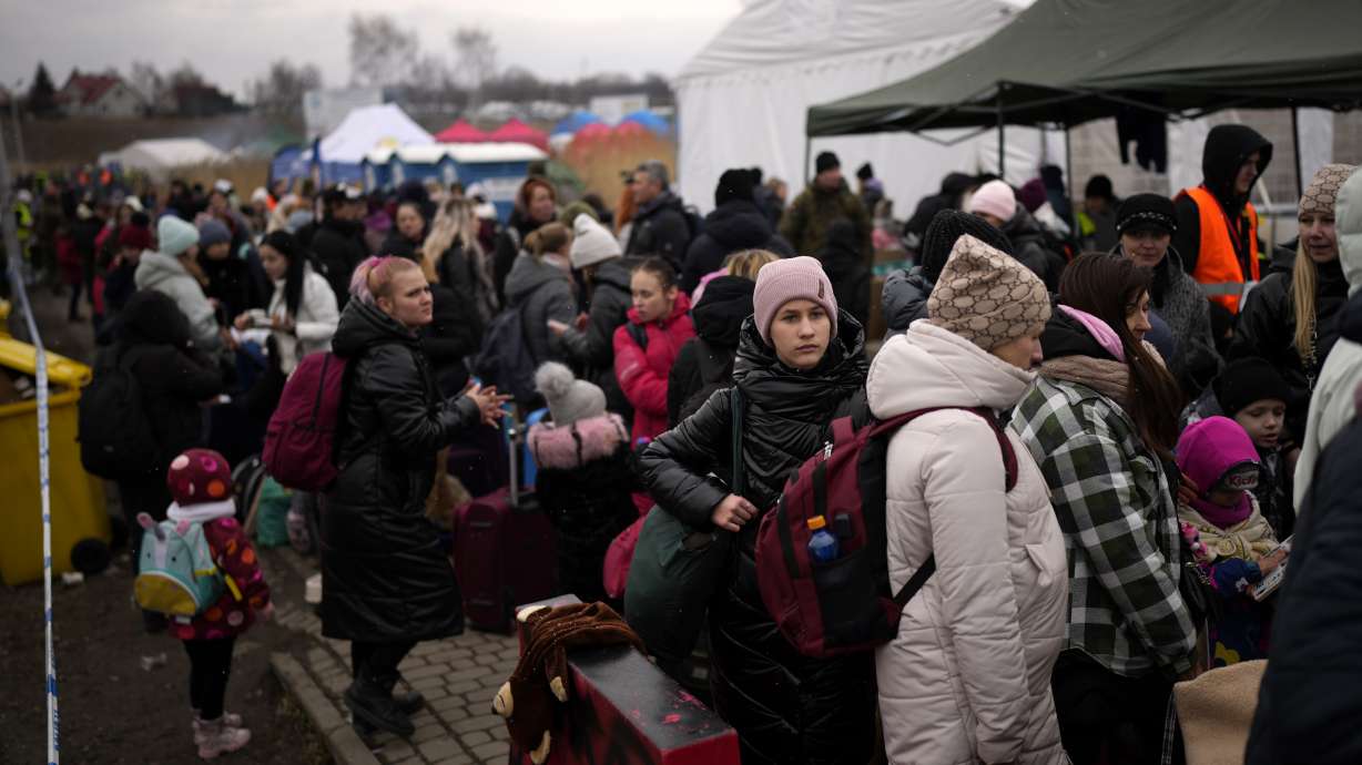 Refugees wait for a bus after crossing from Ukraine in Medyka, Poland, Wednesday, March 9, 2022.