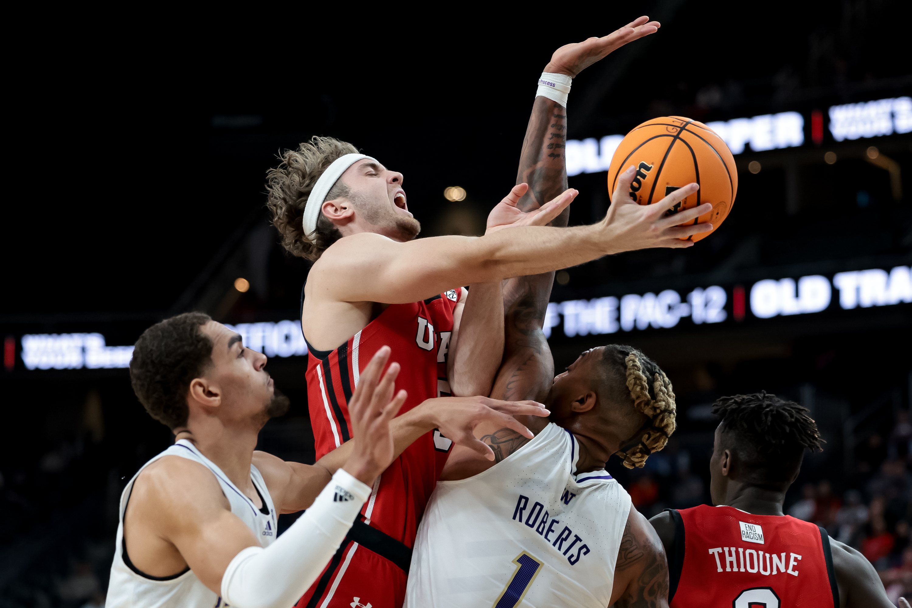 Washington Huskies forward Nate Roberts (1) is charged with a foul as Utah Utes guard Jaxon Brenchley (5) goes to the hoop during a first-round Pac-12 tournament game at T-Mobile Arena in Las Vegas on Wednesday, March 9, 2022.