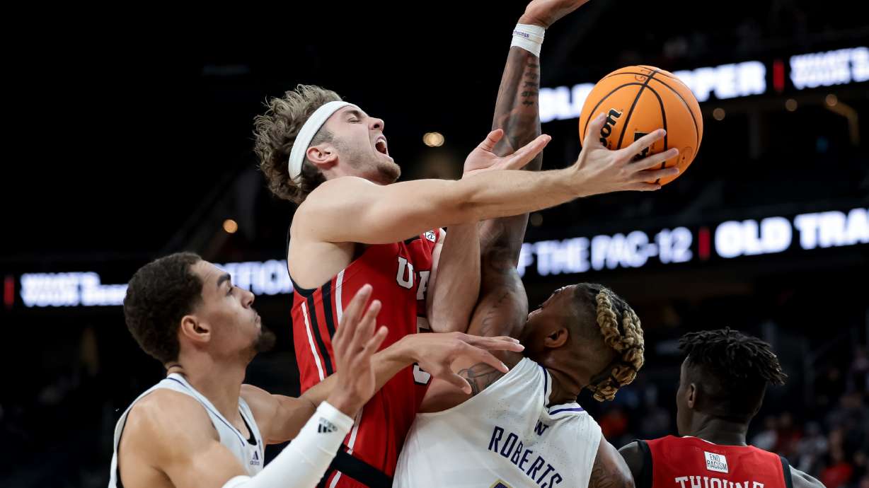 Washington Huskies forward Nate Roberts (1) is charged with a foul as Utah Utes guard Jaxon Brenchley (5) goes to the hoop during a first-round Pac-12 tournament game at T-Mobile Arena in Las Vegas on Wednesday, March 9, 2022.
