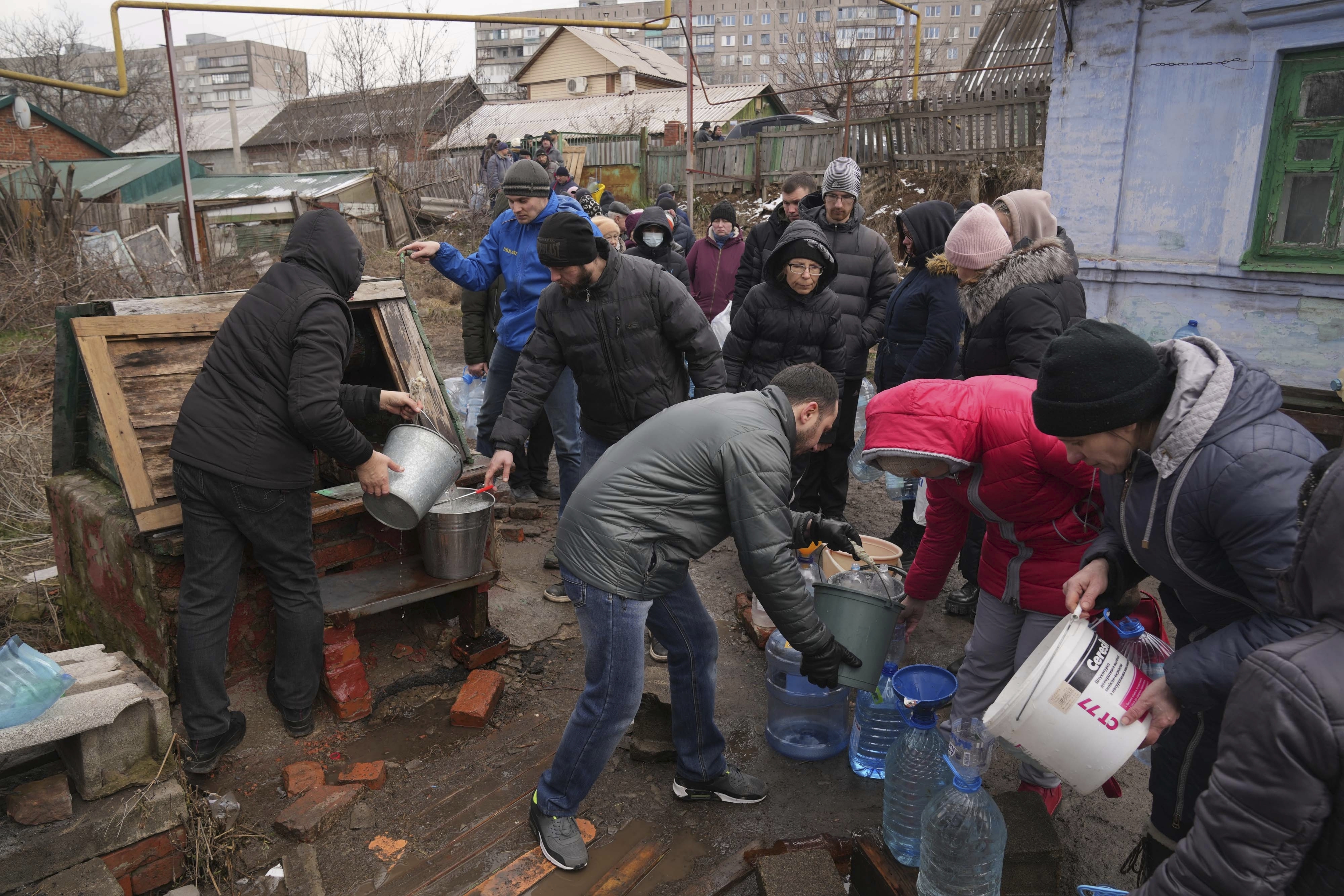 People line up to get water at the well in outskirts of Mariupol, Ukraine, Wednesday. A Russian attack has severely damaged a maternity hospital in the besieged port city of Mariupol, Ukrainian officials say.
