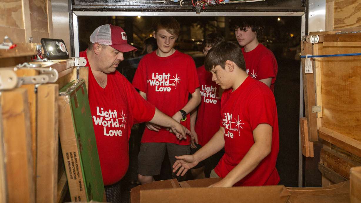 Bishop Tim Bird, left, works with Anthony Buchanan, 18, Jordan Johnson, 16, Dio Garcia, 16 and Charlie Taylor, 16, as they unload furnishings collected through giving machines as part of The Church of Jesus Christ of Latter-day Saints' Light the World initiative on Dec. 10, 2021, in San Antonio, Texas.