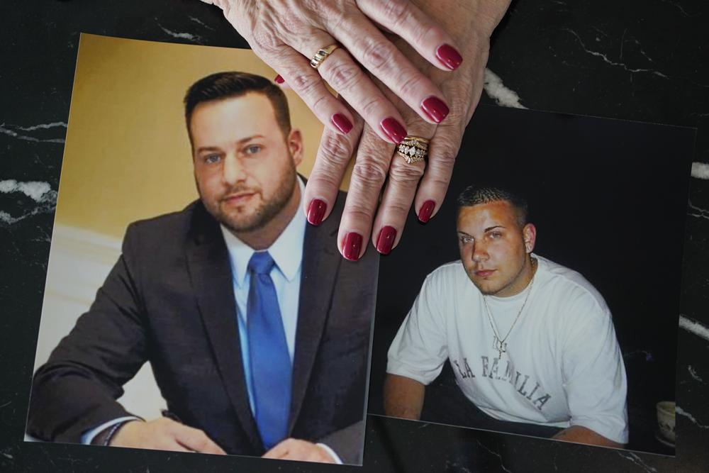 Cheryl Juaire holds photos of her sons, both of whom died from overdoses, Sean Merrill, left, and Corey Merrill, after making a statement during a hearing in New York, Thursday. Victims of opioids and those who have lost loved ones to the addiction crisis are unleashing their emotions on members of the family they blame for fueling the deadly epidemic.