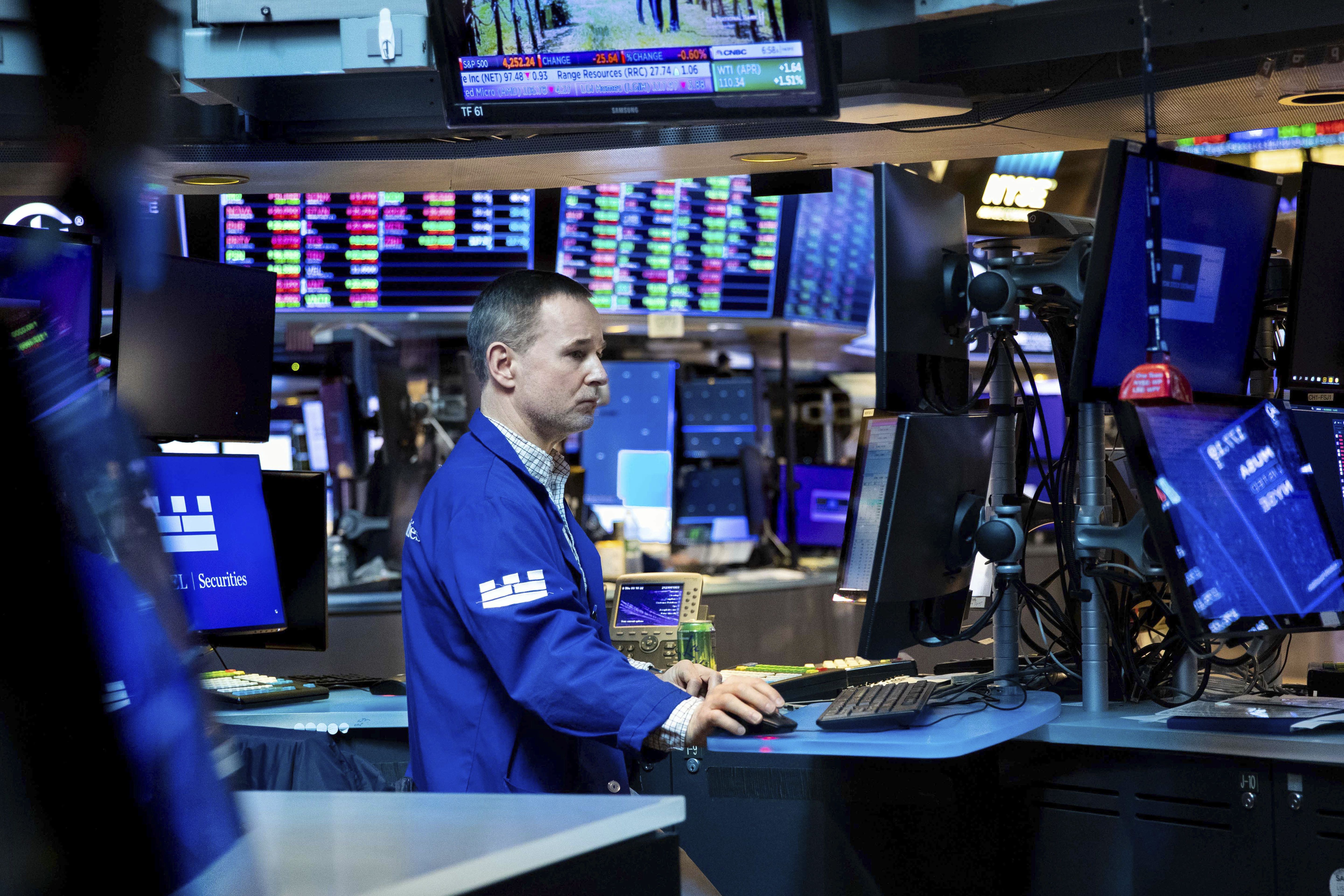 New York Stock Exchange specialist Stephen Naughton works at his post on the trading floor, Thursday. Back down went stocks on Wall Street Thursday as global markets keep swinging on uncertainty about where inflation, interest rates and the global economy are heading.