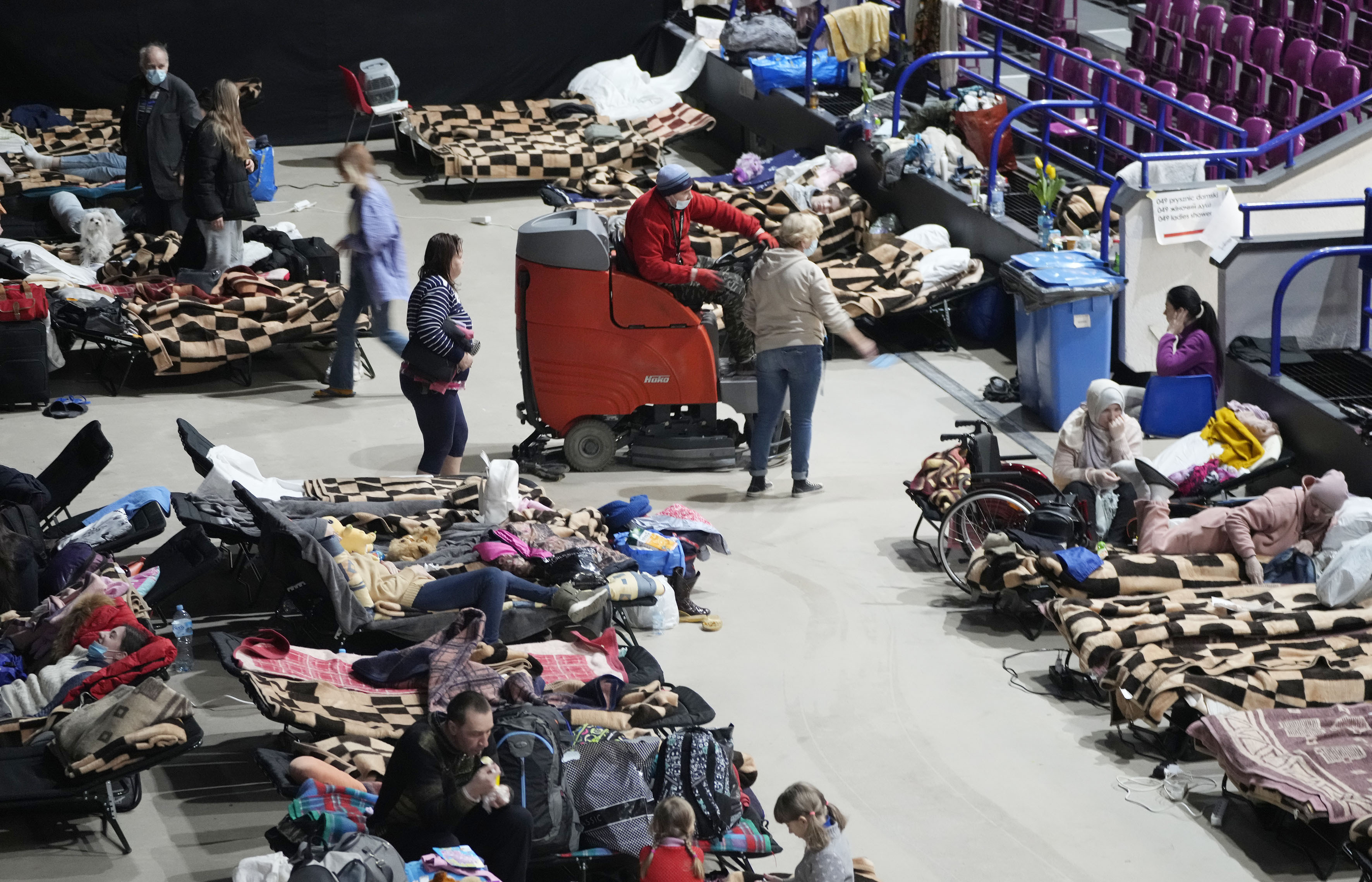 Refugees from the war in Ukraine seek shelter in a sports center in Warsaw, Poland, on Friday.