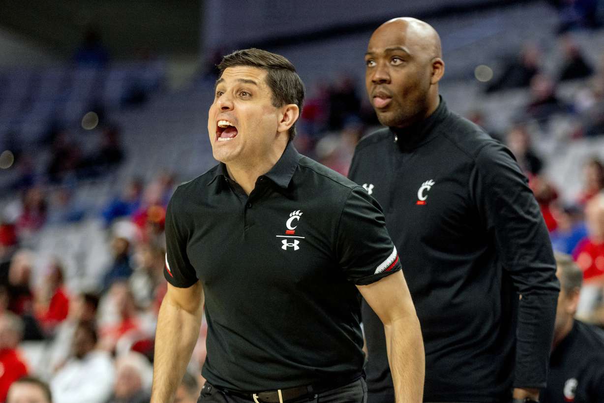 Cincinnati head coach Wes Miller, left, shouts a play to his team during the first half of an NCAA college basketball game against Houston in the quarterfinals of the American Athletic Conference tournament in Fort Worth, Texas, Friday, March 11, 2022.