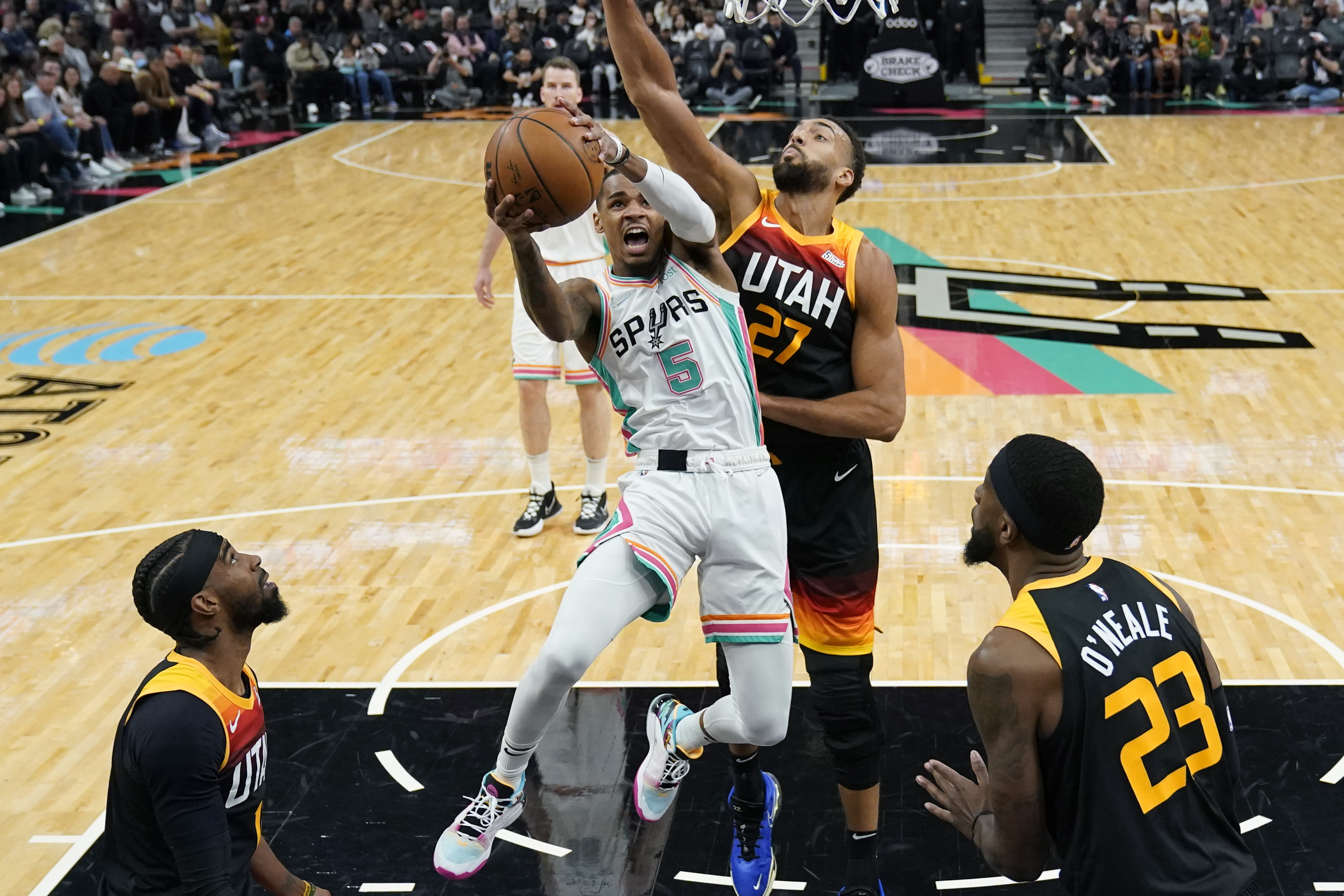 San Antonio Spurs guard Dejounte Murray (5) drives to the basket against Utah Jazz center Rudy Gobert (27) during the first half of an NBA basketball game, Friday, March 11, 2022, in San Antonio.