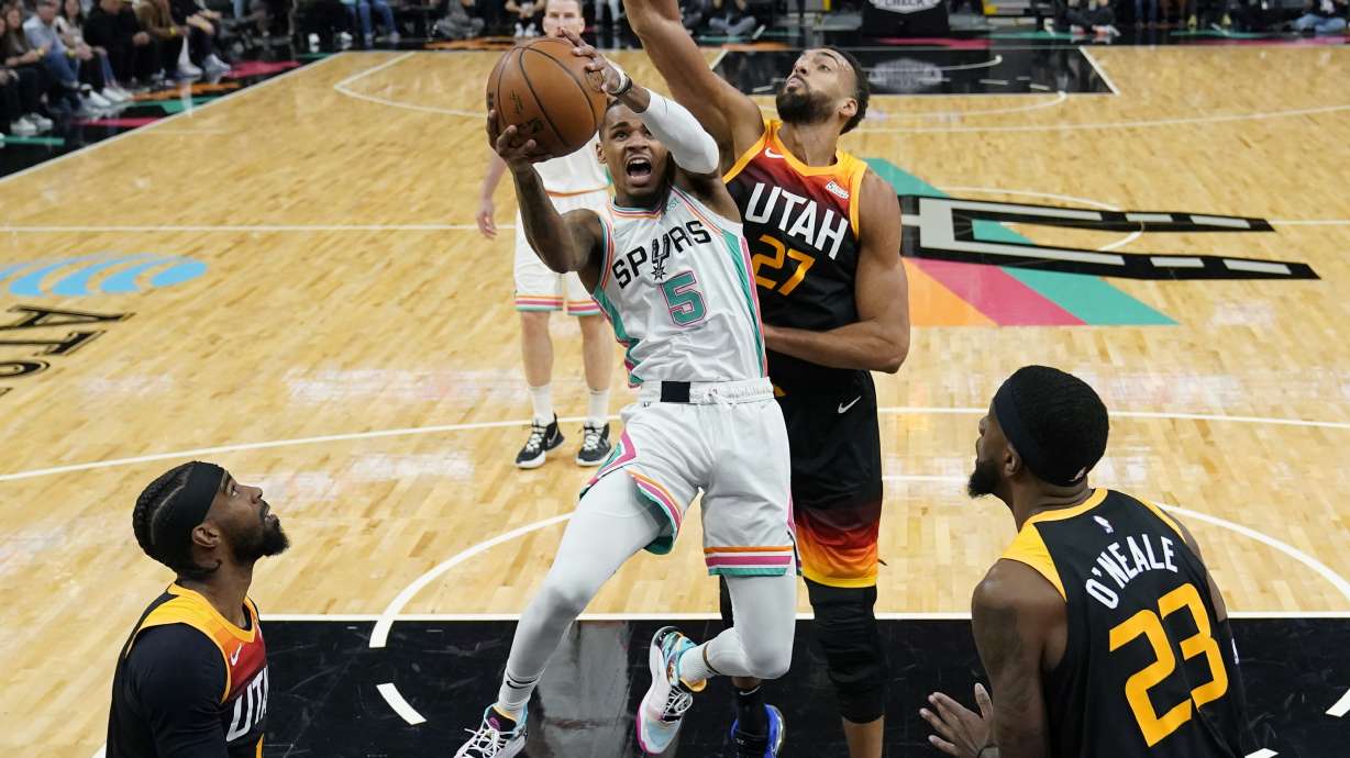 San Antonio Spurs guard Dejounte Murray (5) drives to the basket against Utah Jazz center Rudy Gobert (27) during the first half of an NBA basketball game, Friday, March 11, 2022, in San Antonio.