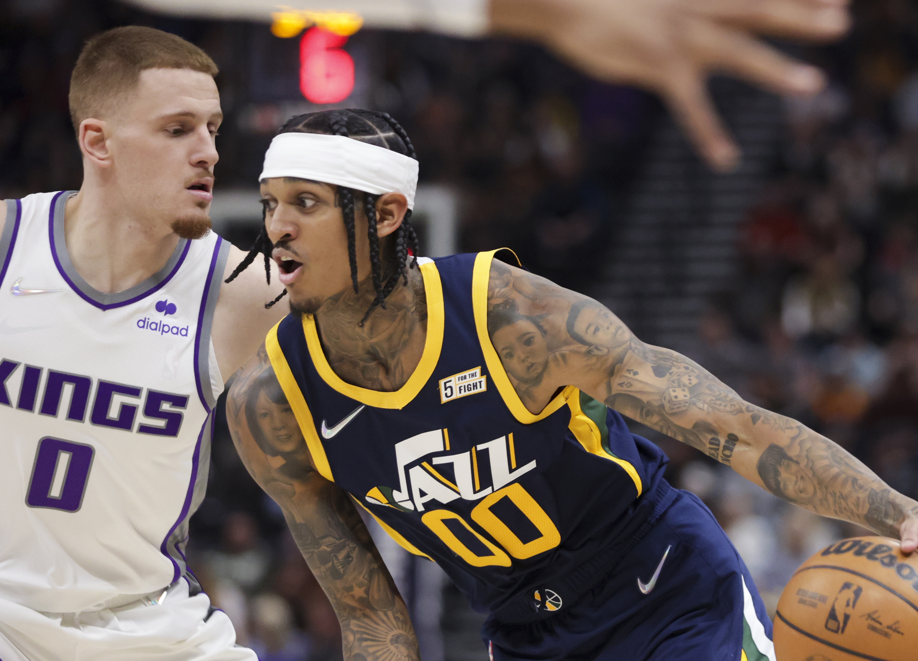 Utah Jazz guard Jordan Clarkson (00) drives over Sacramento Kings guard Donte DiVincenzo (0) as the Utah Jazz and the Sacramento Kings play an NBA basketball game at Vivint Arena in Salt Lake City on Saturday, March 12, 2022.