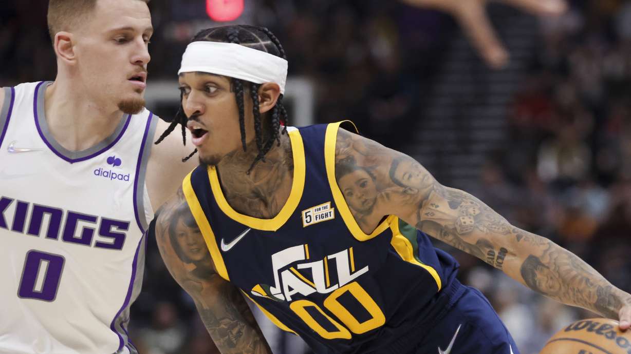 Utah Jazz guard Jordan Clarkson (00) drives over Sacramento Kings guard Donte DiVincenzo (0) as the Utah Jazz and the Sacramento Kings play an NBA basketball game at Vivint Arena in Salt Lake City on Saturday, March 12, 2022.