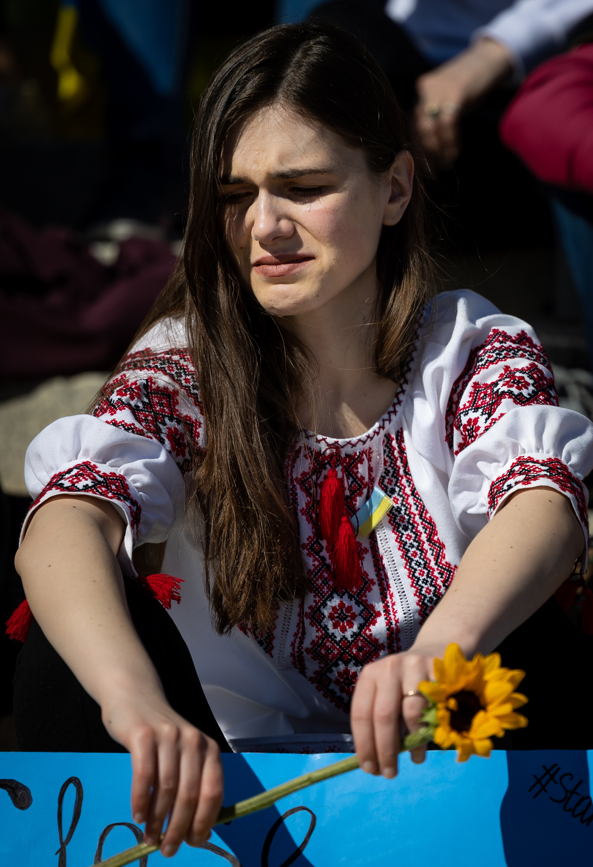 Albina Truax, who has family in Mariupol, Ukraine, sits on the steps of the Capitol in Salt Lake City during a rally against the war in Ukraine on Saturday.