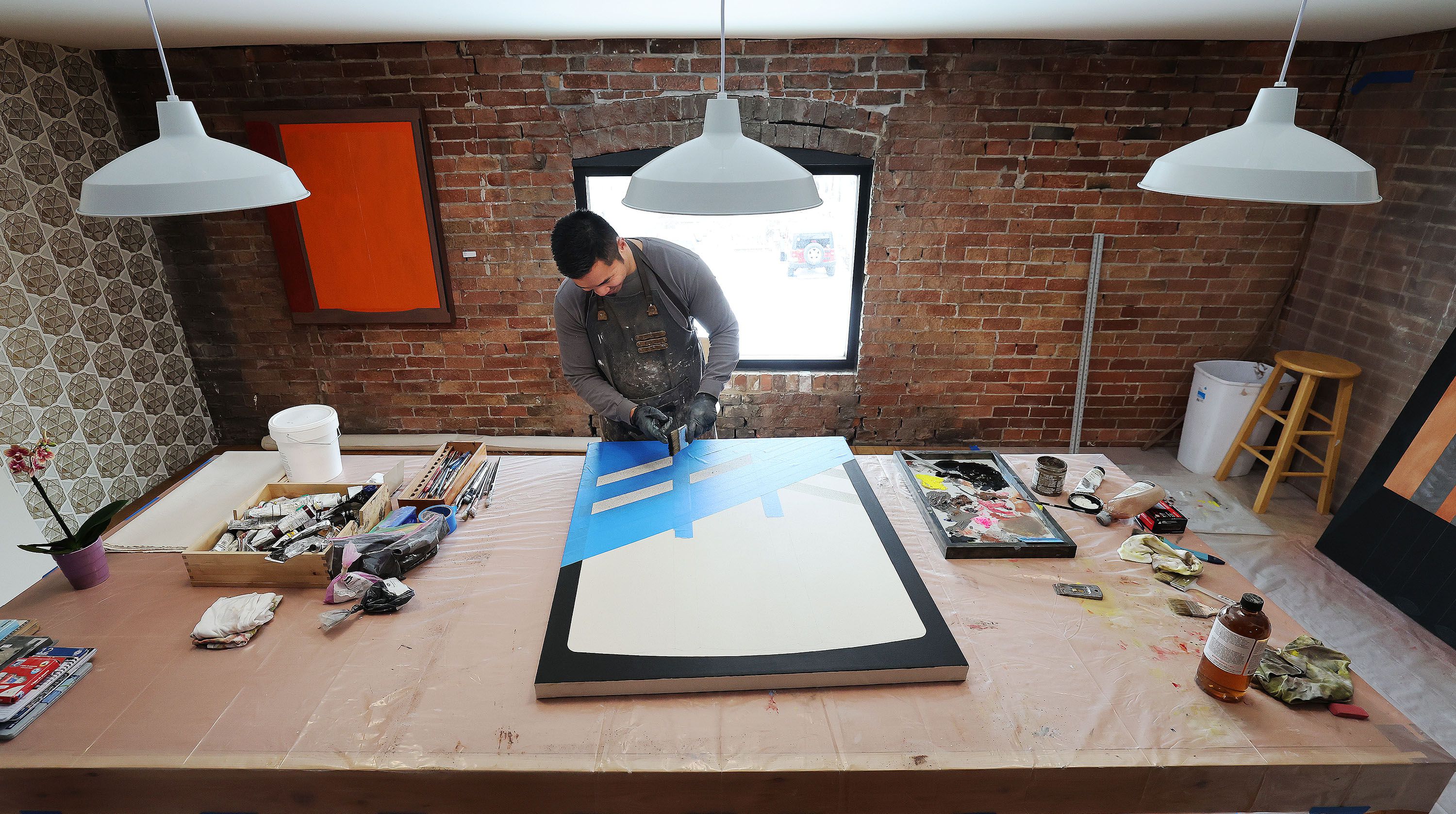 Artist-in-residence Kheng Lim works on a project at Modern West Fine Art in Salt Lake City on Wednesday.