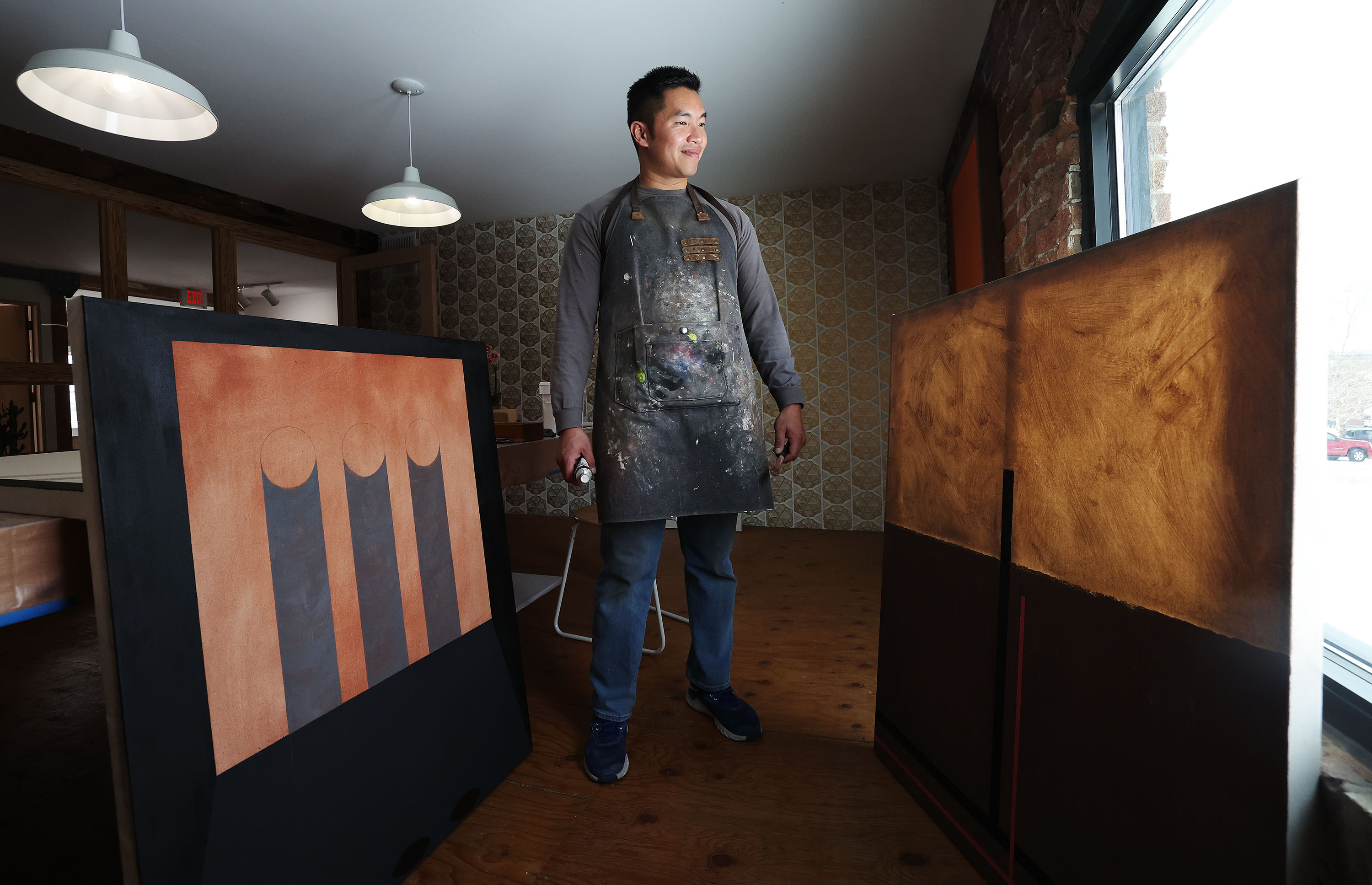Artist-in-residence Kheng Lim poses with some of his works in progress at Modern West Fine Art in Salt Lake City on Wednesday.