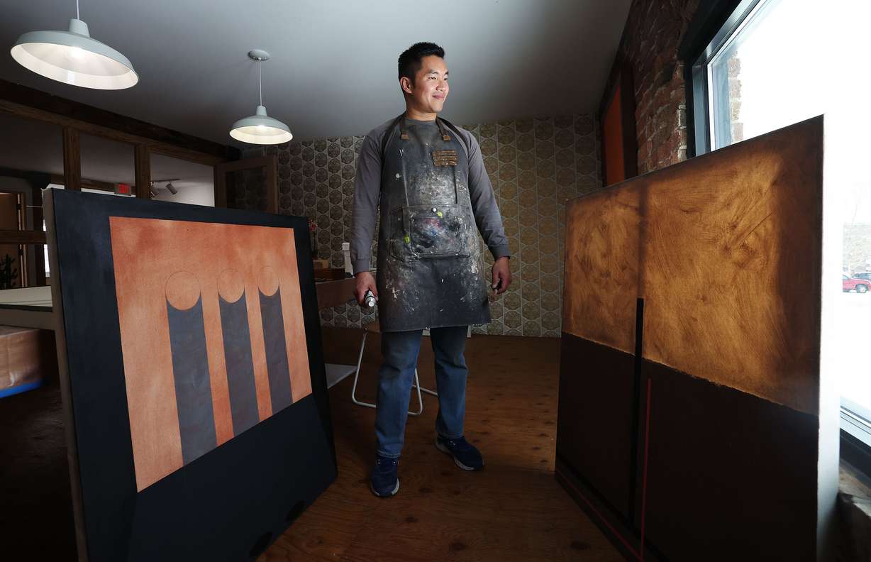Artist-in-residence Kheng Lim poses with some of his works in progress at Modern West Fine Art in Salt Lake City on Wednesday.