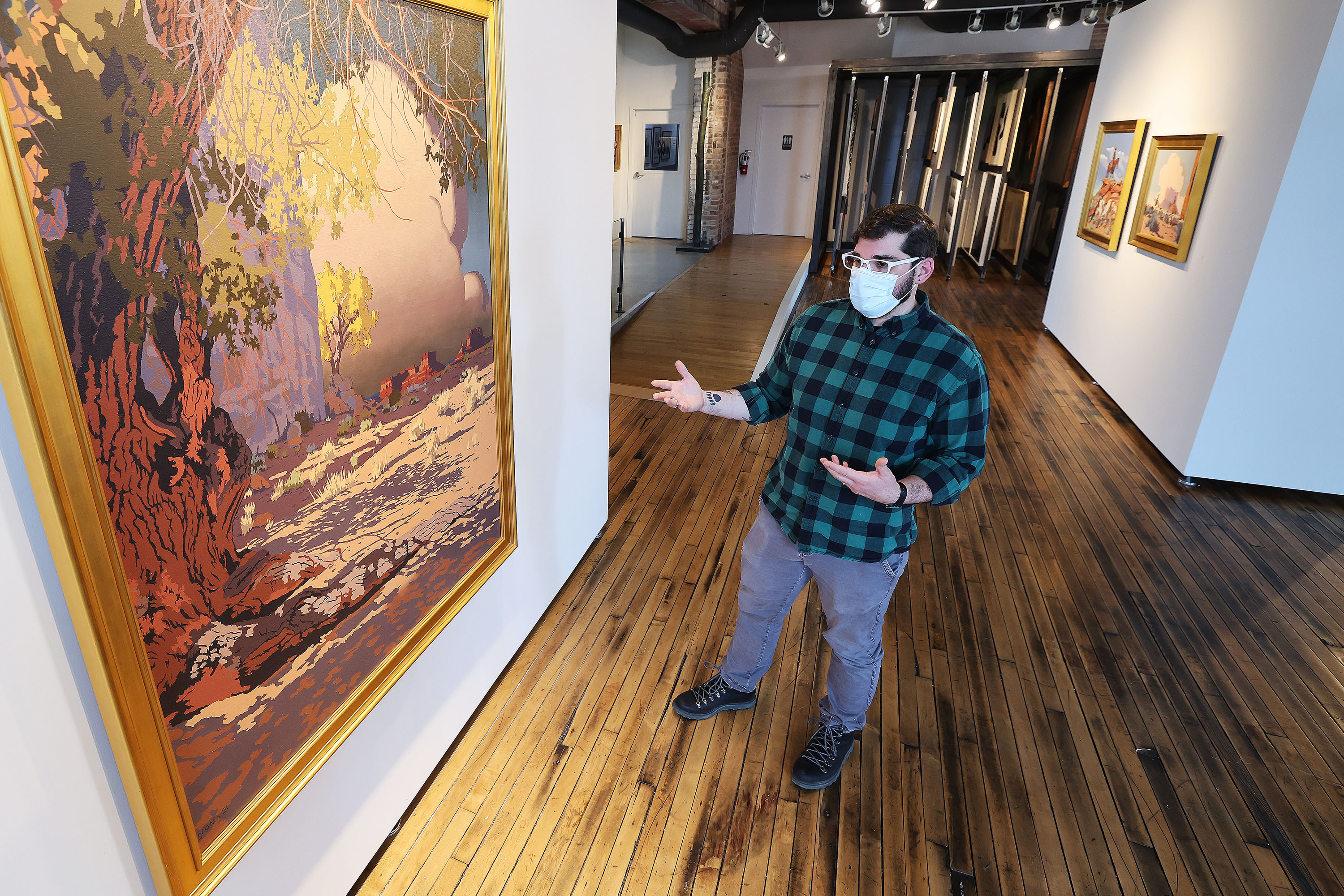 Peter Hay, manager of the artist-in-residence  program at Modern West Fine Art, talks about the art in the gallery in Salt Lake City on Wednesday.