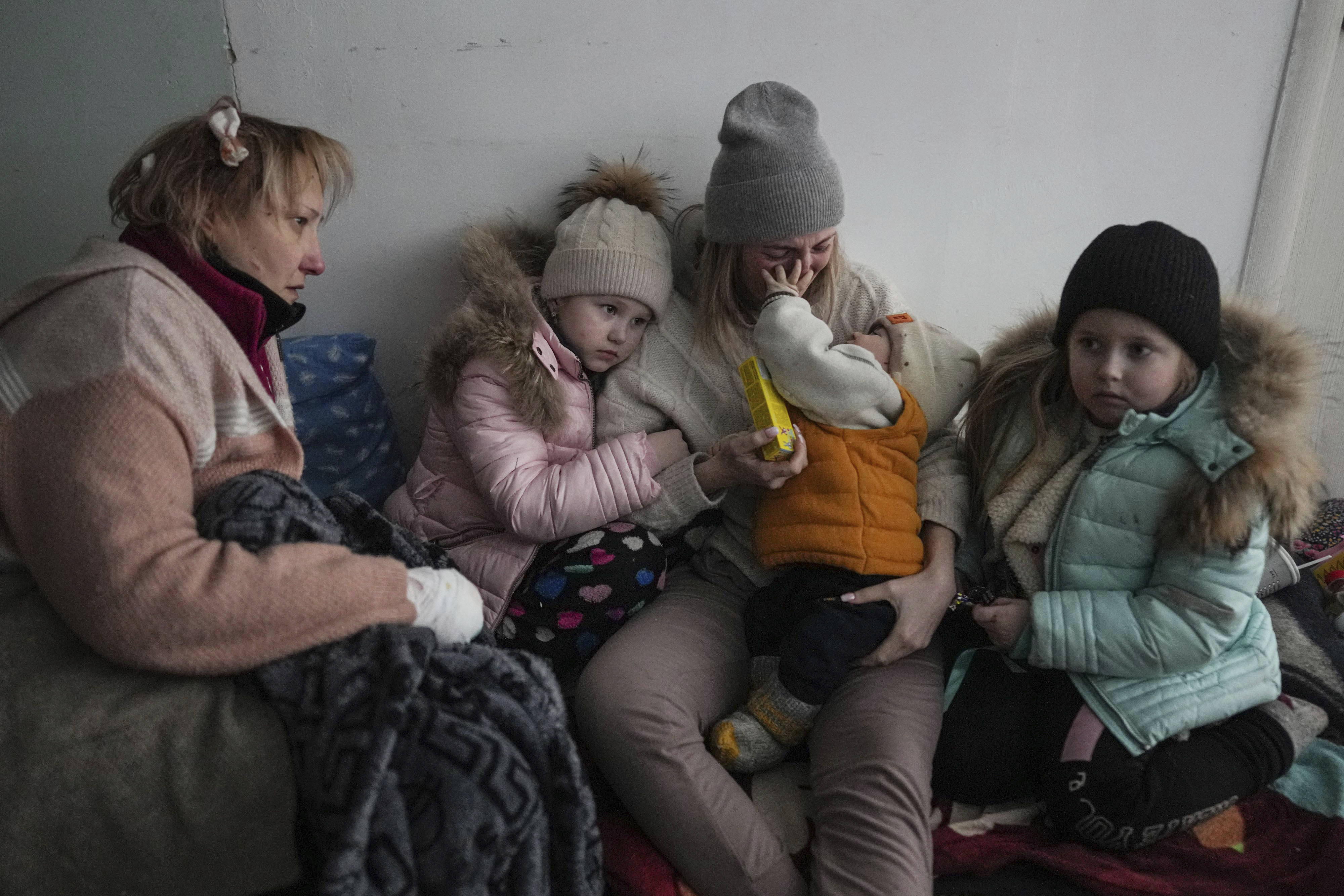 Women and children sit on the floor of a corridor in a hospital in Mariupol, eastern Ukraine Friday. Mariupol has been under siege for over a week, with no electricity, gas or water. Repeated efforts to evacuate people from the city of 430,000 have fallen apart as humanitarian convoys come under shelling.