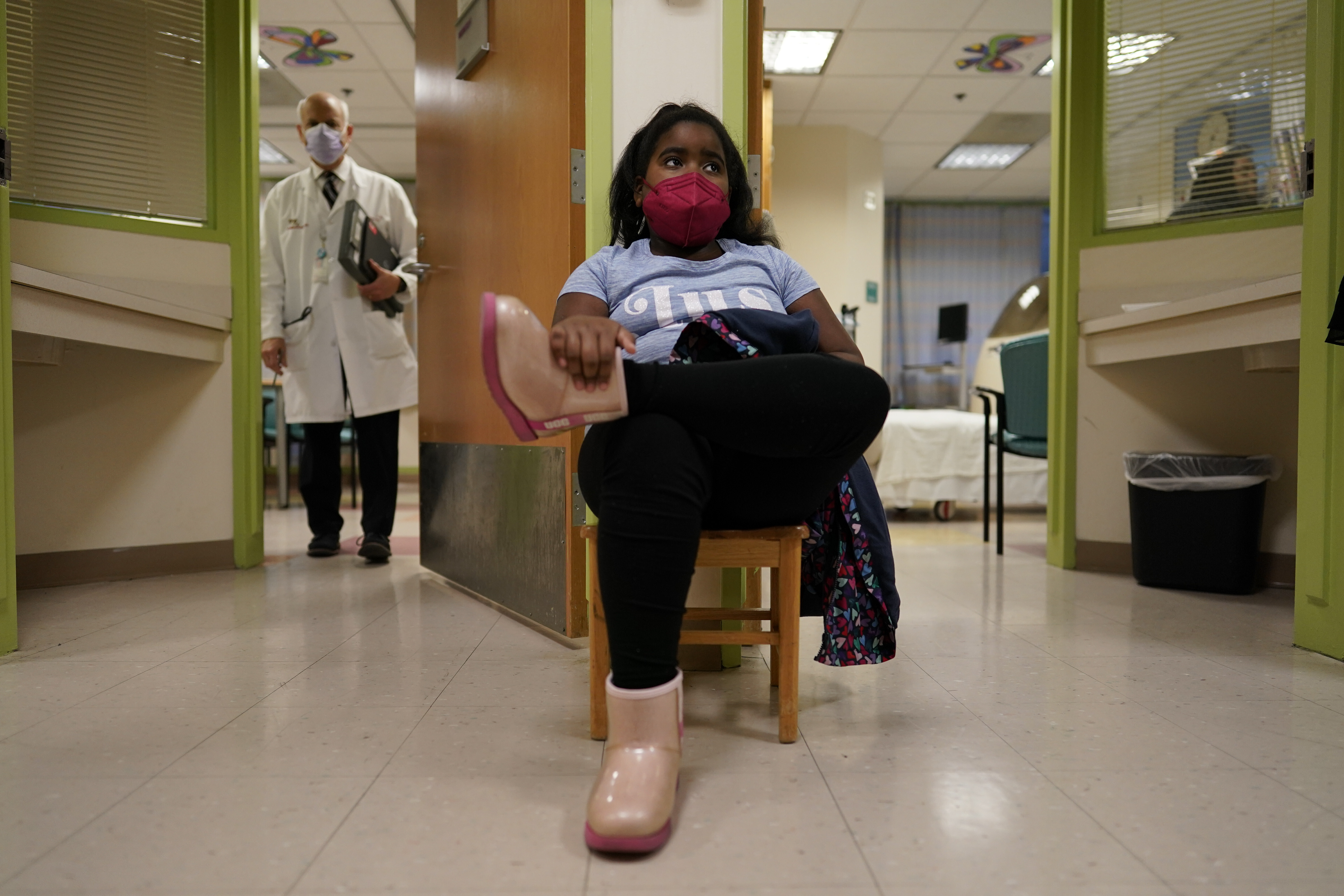 Brooklynn Chiles, 8, sits outside exam rooms during a follow-up visit to Children's National Hospital in Washington, Feb. 11. Brooklynn's father, Rodney Chiles, died of COVID-19 last year and she has tested positive three times. 