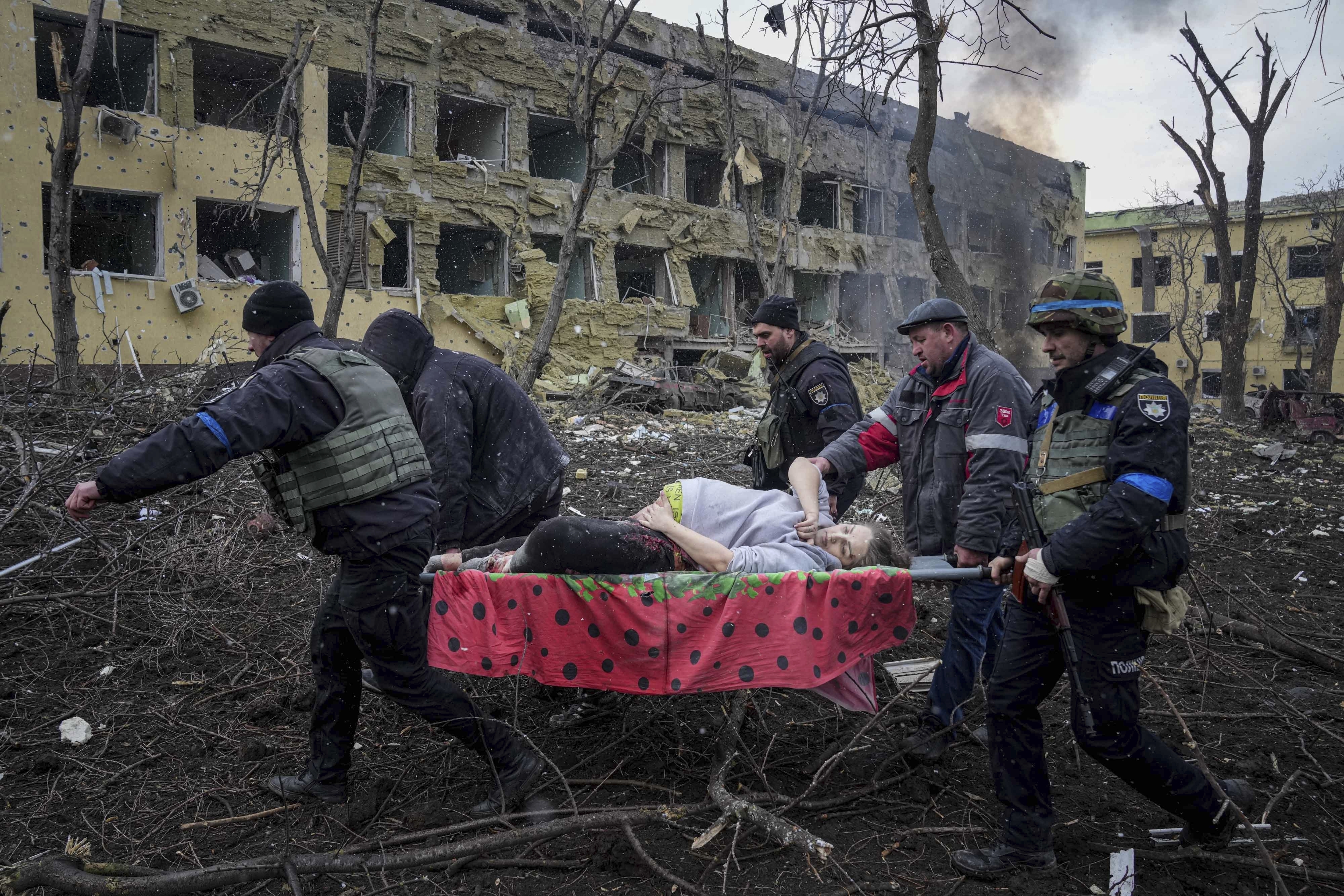 Ukrainian emergency employees and volunteers carry an injured pregnant woman from a maternity hospital that was damaged by shelling in Mariupol, Ukraine, on March 9. The woman and her baby died after Russia bombed the maternity hospital where she was meant to give birth. 