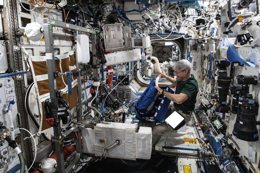 Astronaut Mark Vande Hei sets up an exercise bicycle inside the U.S. Destiny laboratory module on June 22, 2021. Vande Hei has made it through nearly a year in space, but in March 2022 faces what could be his trickiest assignment yet: riding a Russian capsule back to Earth in the midst of deepening tensions between the countries.