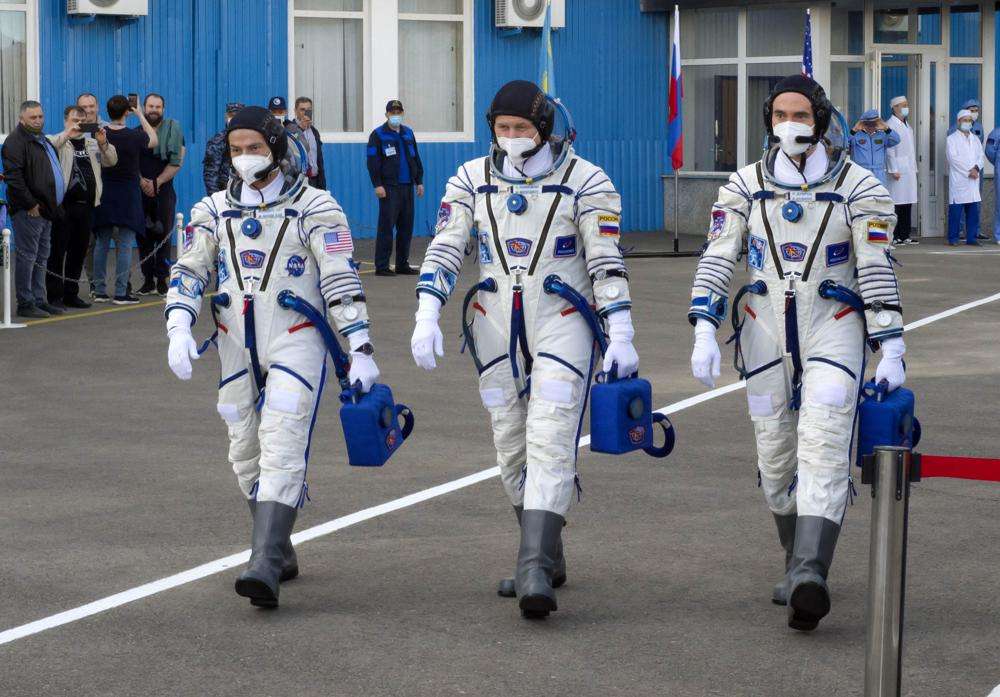 Fom left, U.S. astronaut Mark Vande Hei, Russian cosmonauts Oleg Novitsky and Pyotr Dubrov, members of the main crew to the International Space Station, walk prior to the launch at the Russian leased Baikonur cosmodrome, Kazakhstan, April 9, 2021. Vande Hei has made it through nearly a year in space, but in March 2022 faces what could be his trickiest assignment yet: riding a Russian capsule back to Earth in the midst of deepening tensions between the countries.