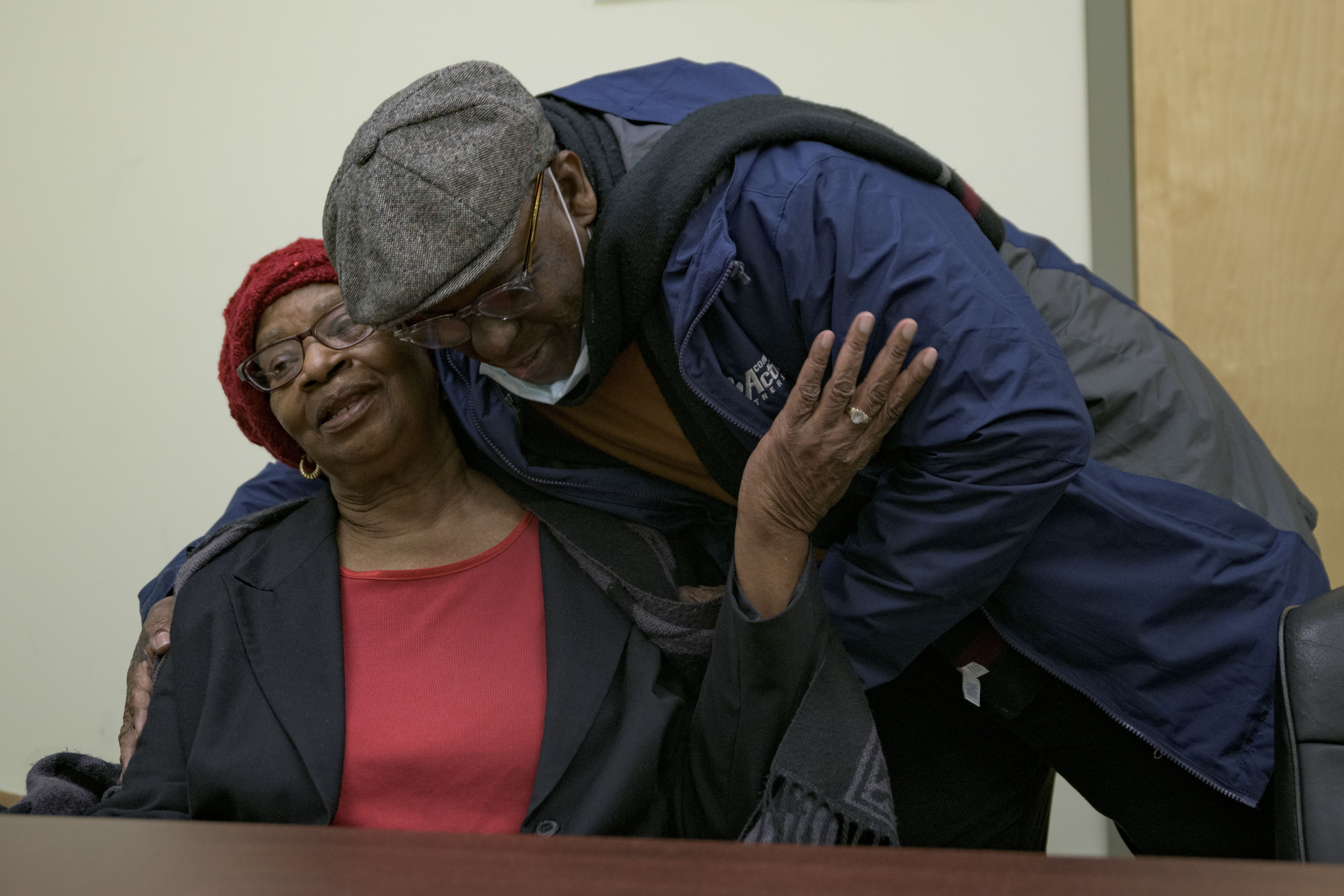 Mary Boyd is hugged by Glenis Scott at Total Community Action in New Orleans, Feb. 4. Boyd, who is 83 and lives in New Orleans, said her expensive energy utility bills were causing her to choose between medication, and other expenses.