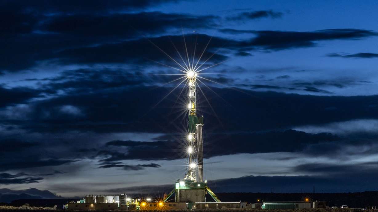 An oil rig drills a well near Roosevelt on Sunday. As fighting grips oil overseas, an argument over fossil fuel rages in the United States.