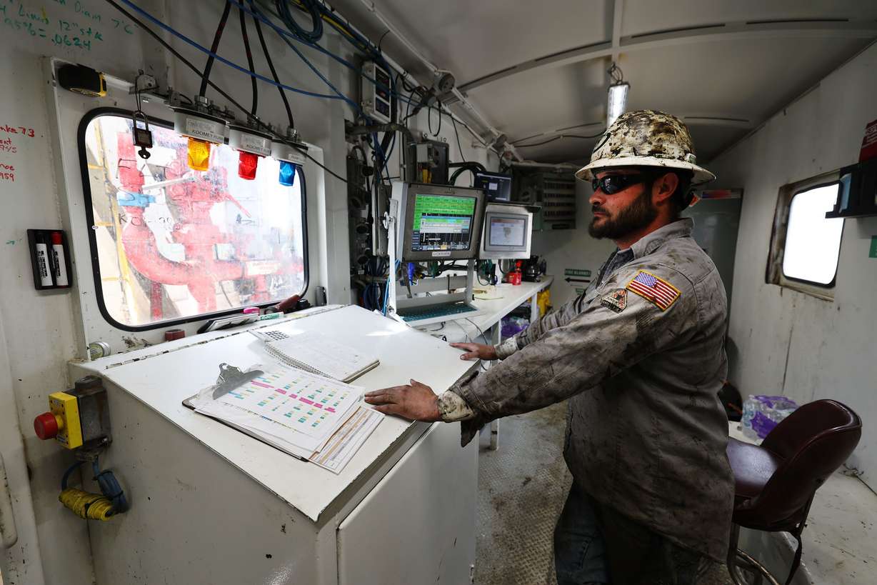 Driller Cache Edrington watches the drill from inside a housing on a rig near Roosevelt on Sunday.