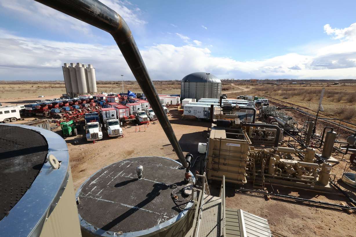 Workers operate a central manifold at an oil fracking site near Roosevelt on Sunday.
