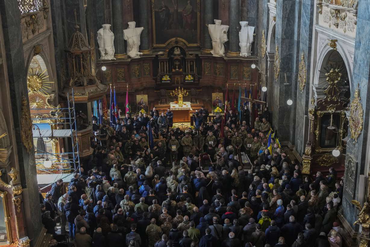 People attend a funeral ceremony for four of the Ukrainian military servicemen, who were killed during an airstrike in a military base in Yarokiv, in a church in Lviv, Ukraine, Tuesday. At least 35 people were killed and many wounded in Sunday's Russian missile strike on a military training base near Ukraine's western border with NATO member Poland.