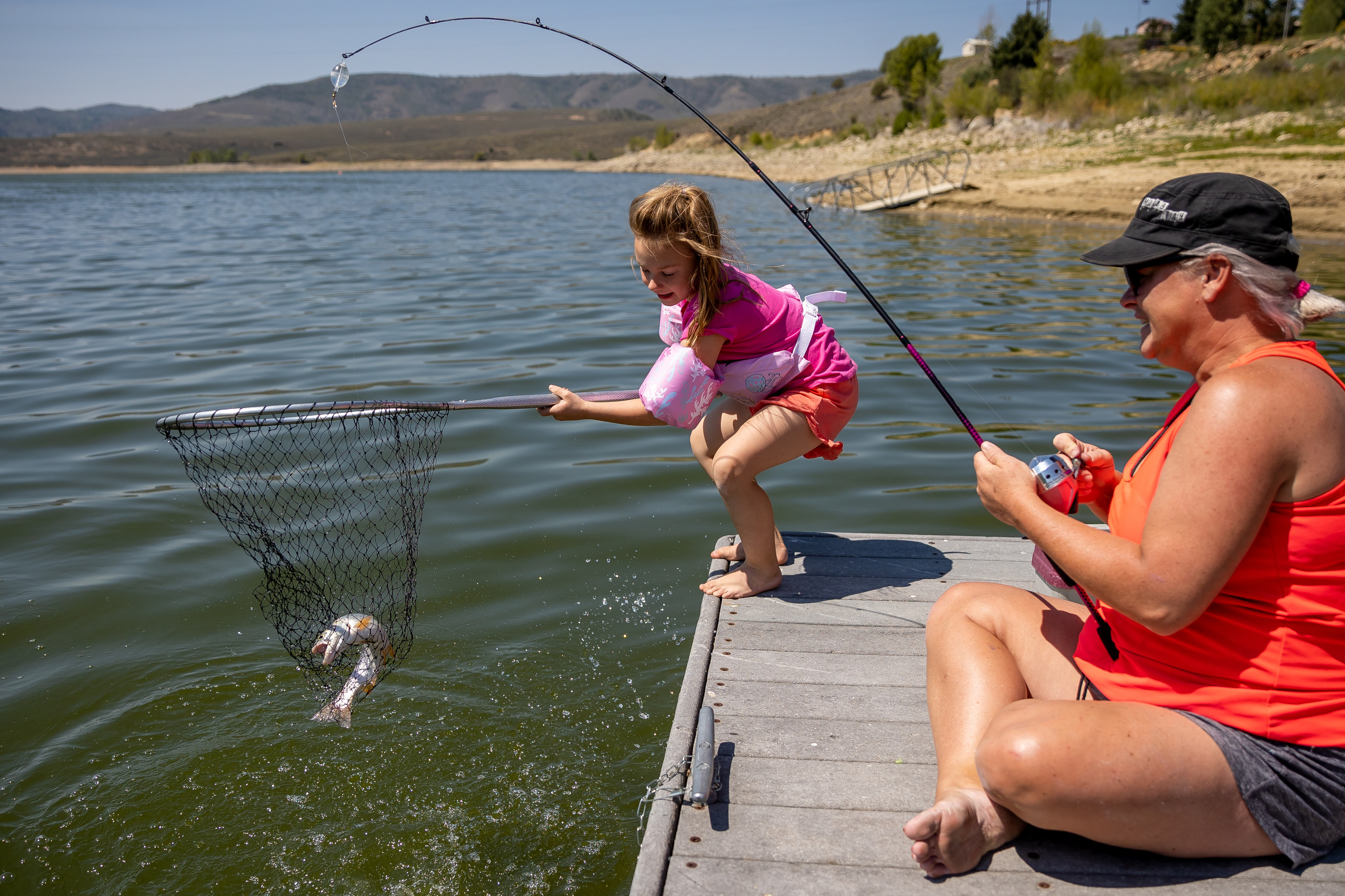 Presley Morse, 6, helps land a cutthroat trout while fishing with her mother, Jill Gilson, at Scofield State Park on Aug. 27, 2021.