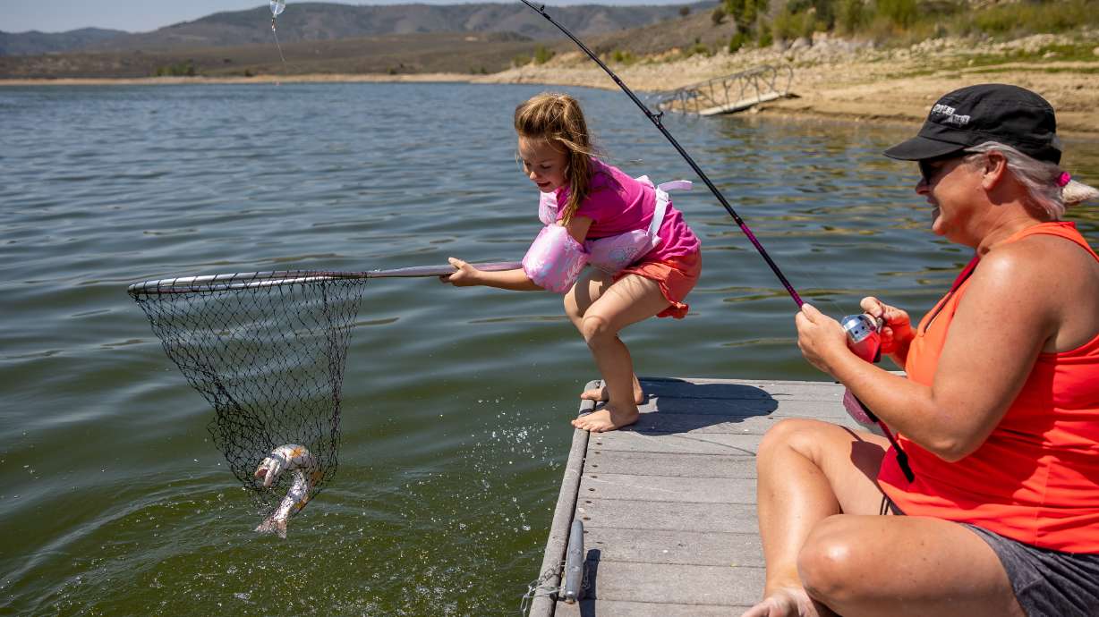 Presley Morse helps land a cutthroat trout while fishing with her mother, Jill Gilson, at Scofield State Park on Aug. 27, 2021. Utah's reservoir levels are much higher this year than the last two years, which is changing this year's fishing outlook.
