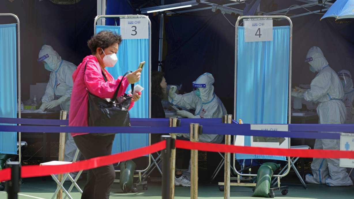 Medical workers help residents to get tested for the coronavirus at a temporary testing center in Hong Kong on Monday. COVID-19 cases are climbing again in much of Europe and Asia, including in China, where the largest surge since the virus first emerged from that country more than two years ago has resulted in several large factory cities being locked down.