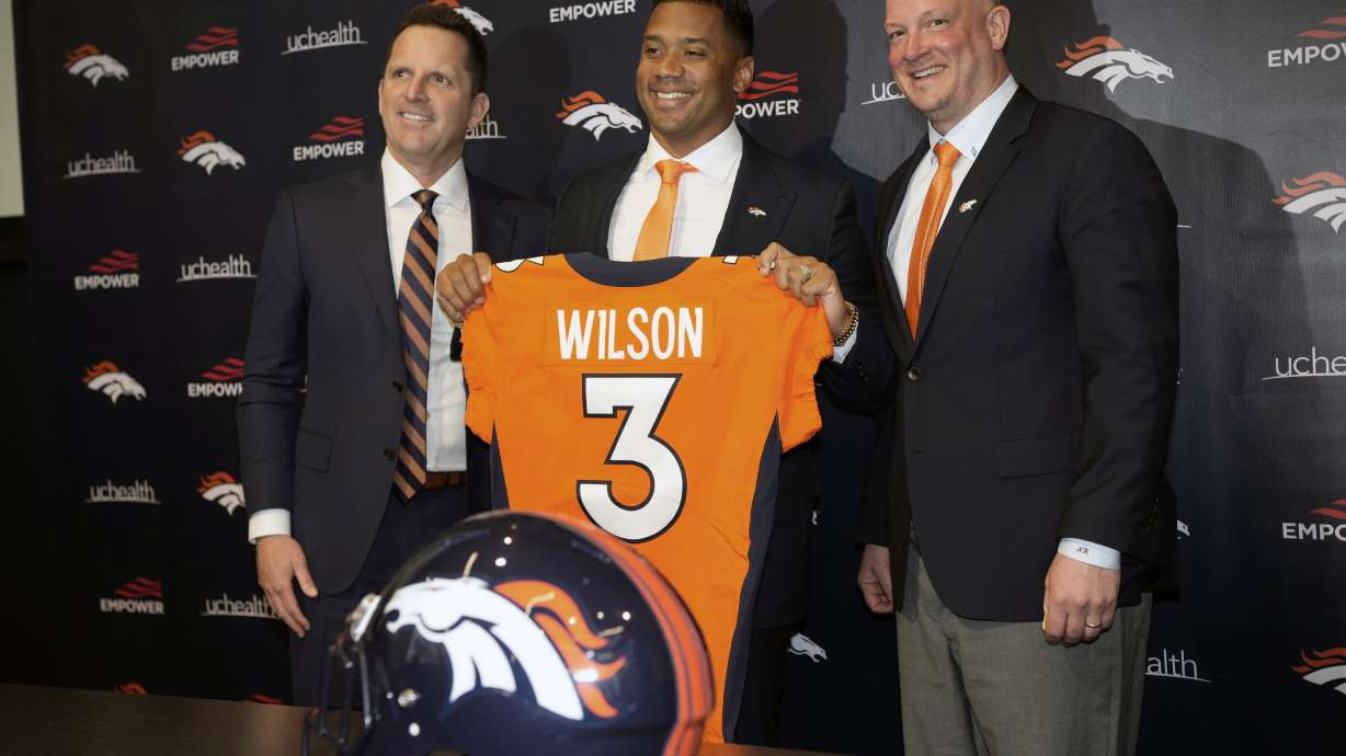 Denver Broncos new starting quarterback Russell Wilson, center, is flanked by head coach Nathaniel Hackett, right, and general manager George Paton after a news conference Wednesday, March 16, 2022, at the team's headquarters in Englewood, Colo.