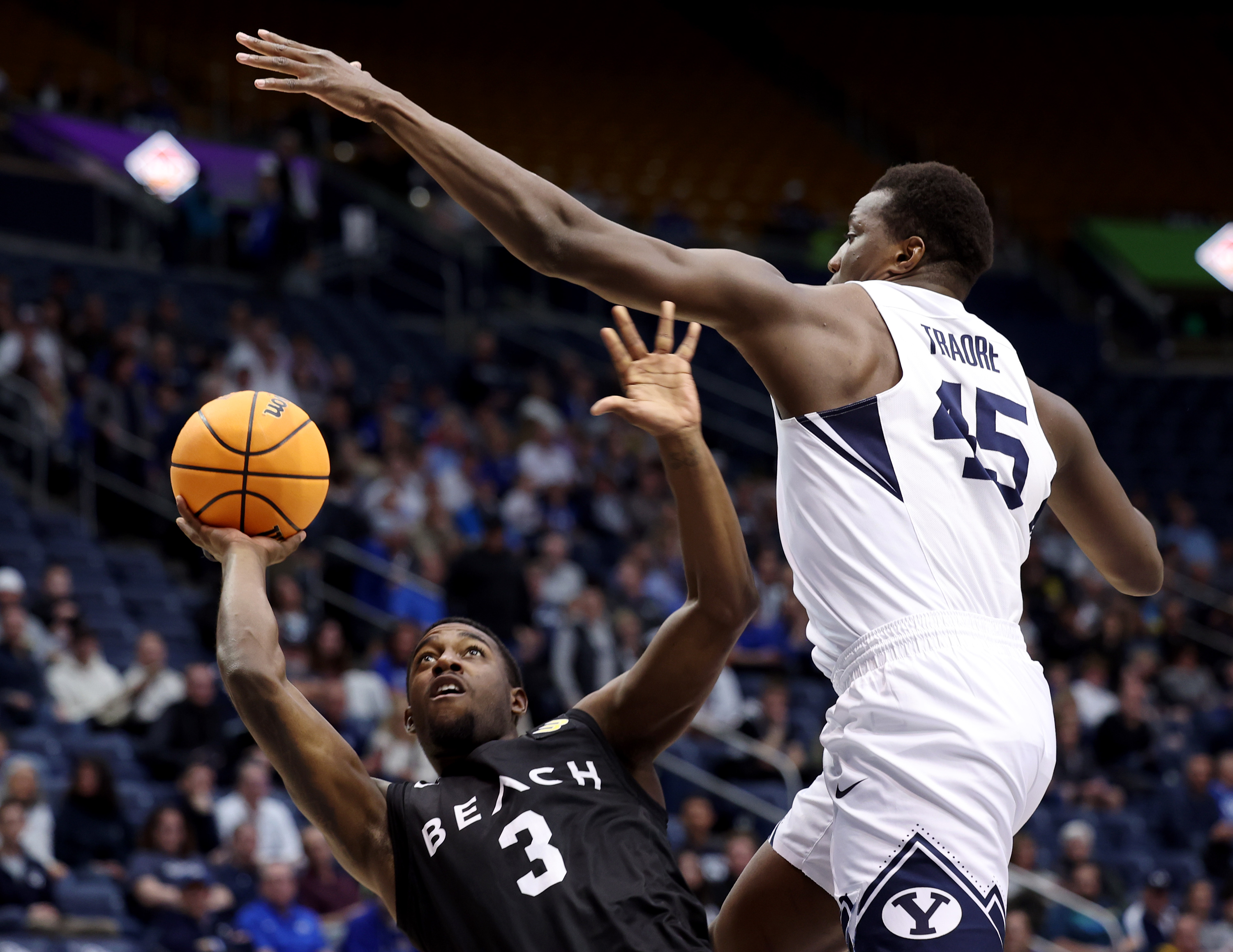 Brigham Young forward Fousseyni Traore (45) blocks a shot by Long Beach State guard Drew Cobb (3) during an NIT game at the Marriott Center in Provo on Wednesday, March 16, 2022.