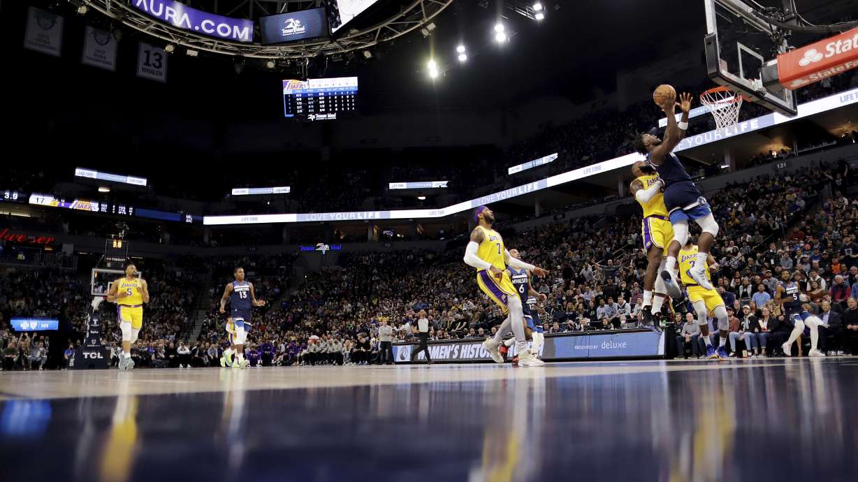Minnesota Timberwolves forward Anthony Edwards shoots next to Los Angeles Lakers forward LeBron James (6) during the first half of an NBA basketball game Wednesday, March 16, 2022, in Minneapolis.