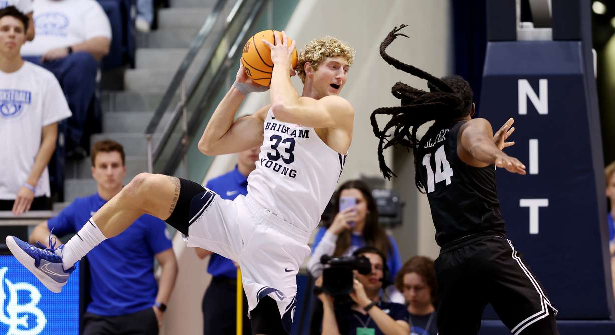Brigham Young forward Caleb Lohner (33) grabs a rebound away from Long Beach State guard Colin Slater (14) during an NIT game at the Marriott Center in Provo on Wednesday, March 16, 2022.