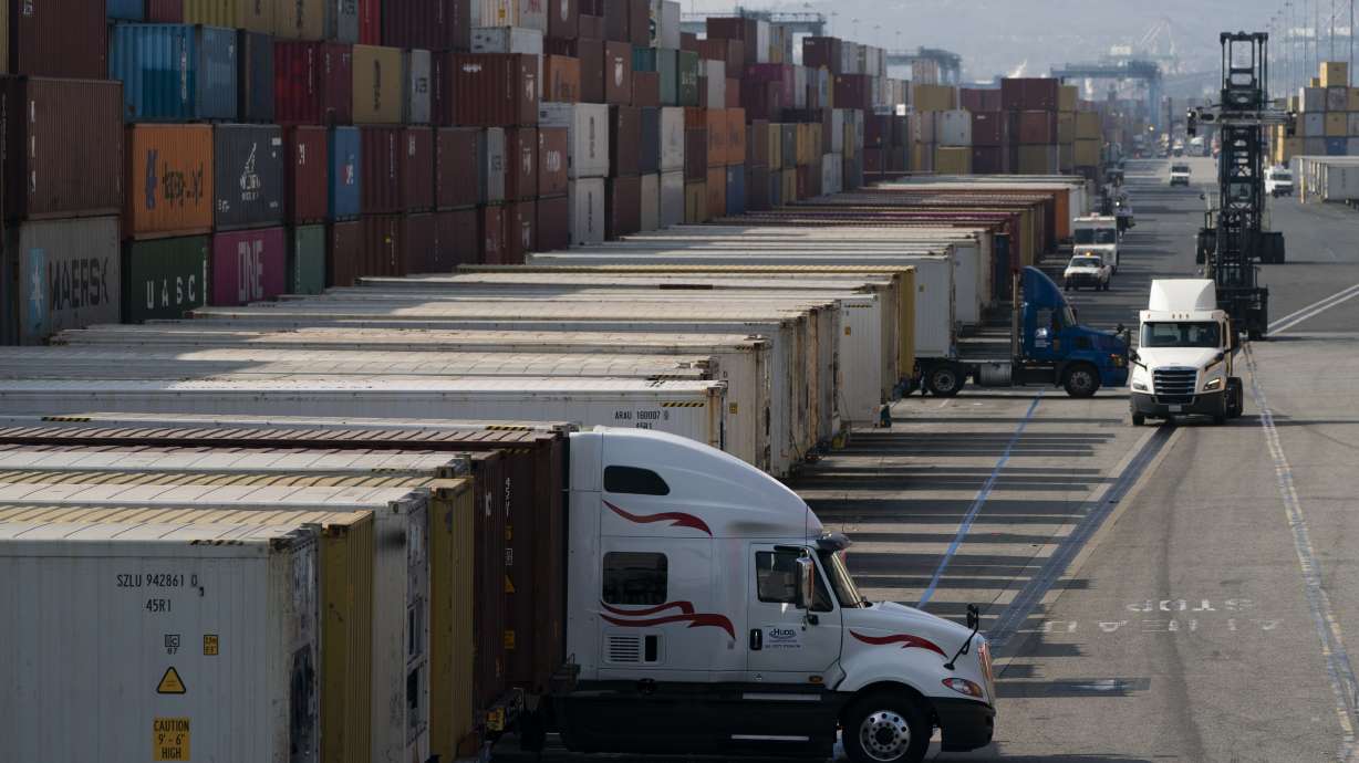 Trucks load and unload shipping containers at the Port of Long Beach in Long Beach, Calif., Nov. 17, 2021. Fewer Americans applied for unemployment benefits last week as layoffs continue to fall amid a strong job market rebound.