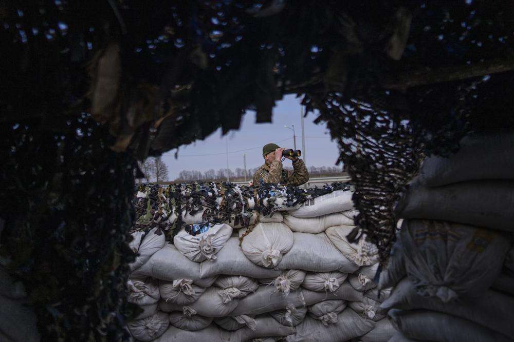 A Ukrainian soldier looks through binoculars at a military check point, in Lityn, Ukraine, Wednesday. The drones, which carry lightweight, laser-guided bombs, have carried out unexpectedly successful attacks in the early stages of Ukraine's conflict with Russia.