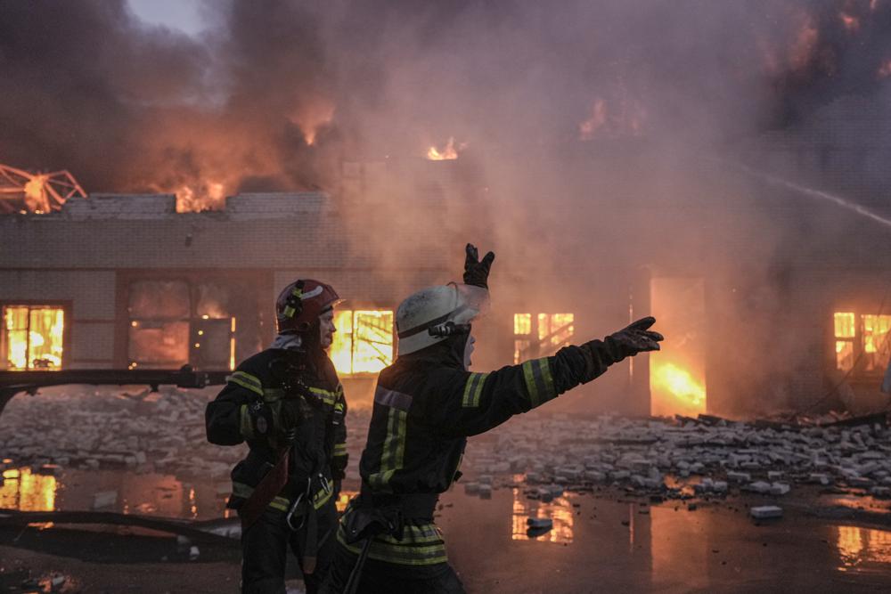 Ukrainian firefighters extinguish a blaze at a warehouse after a bombing in Kyiv, Ukraine, Thursday. Russian forces destroyed a theater in Mariupol where hundreds of people were sheltering Wednesday and rained fire on other cities, Ukrainian authorities said, even as the two sides projected optimism over efforts to negotiate an end to the fighting.