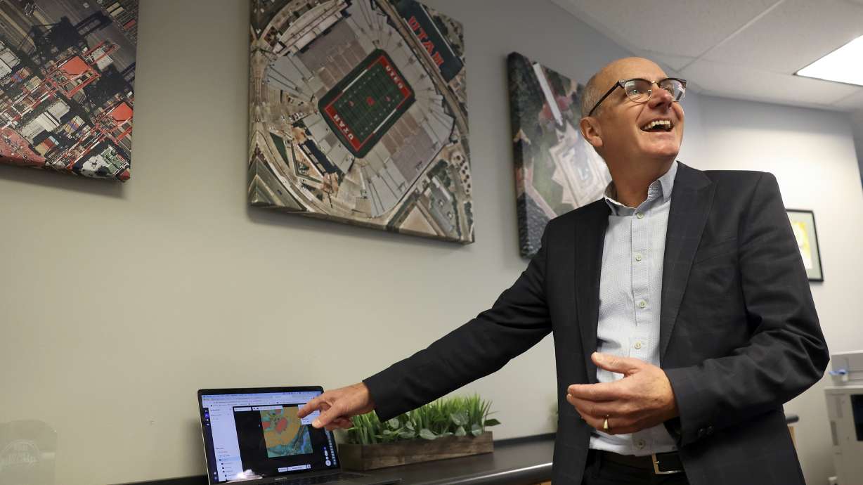 Rob Newman, Nearmap CEO, shows the artificial intelligence layering capabilities of Nearmap technology, at the Nearmap office in South Jordan on Thursday, March 17. Nearmap aerial images hang on the wall behind him.