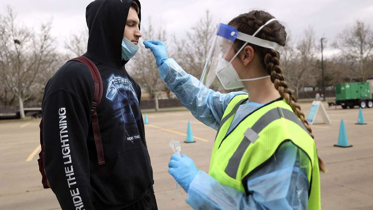 Nurse Megan Christley swabs Mason Stoup’s nose for a COVID-19 test at a Nomi Health testing site outside of the Utah Department of Health building in Salt Lake City on Wednesday.