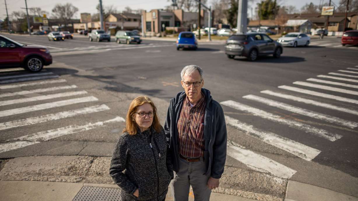 Millcreek residents Victoria and Malcolm Reid pose for a photograph at the corner of 3900 South and 900 East in Millcreek, where three of Utah’s congressional districts converge, on Thursday. The pair are both plaintiffs in a lawsuit that has been filed seeking to overturn the state’s new congressional maps. Where the Reids are standing for the photo is in the 2rd District, across the street on the left is the 4th District and across the street to the right is the 2nd District.