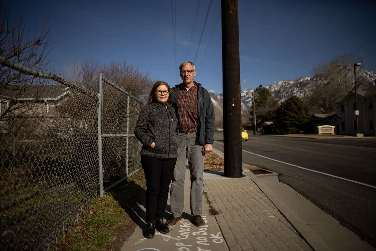 Millcreek residents Victoria and Malcolm Reid pose for a photograph on 3900 South in Millcreek, where three of Utah’s congressional districts converge, on Thursday. The pair are both plaintiffs in a lawsuit that has been filed seeking to overturn the state’s new congressional maps. Where they are standing for the photo, in front of the Reids is the 2nd District, behind them is the 1st District, and on the other side of the road is the 3rd District.