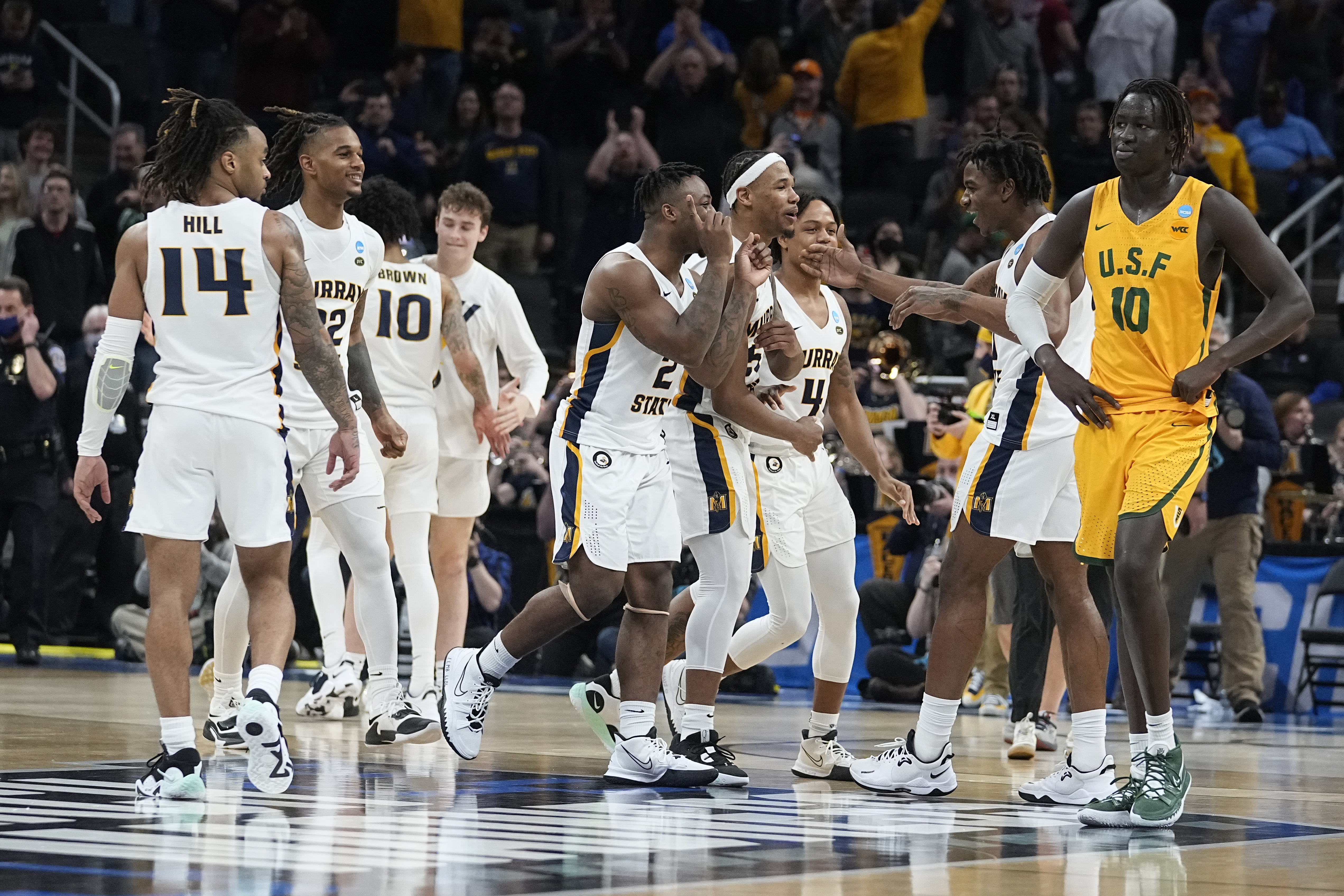Murray State players celebrate as San Francisco forward Josh Kunen (10) walks off the court at the end of a college basketball game in the first round of the NCAA tournament, Friday, March 18, 2022, in Indianapolis. Murray State won 92-87 in overtime. 